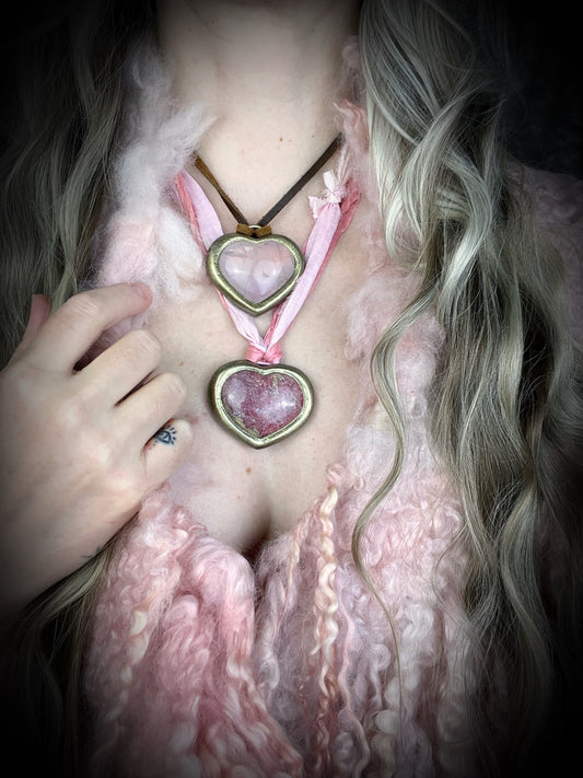 Rhodonite crystal heart necklace with a heart-shaped pink gemstone pendant framed in gold layered with rose quartz necklace on a model. Best Valentines gift for her!