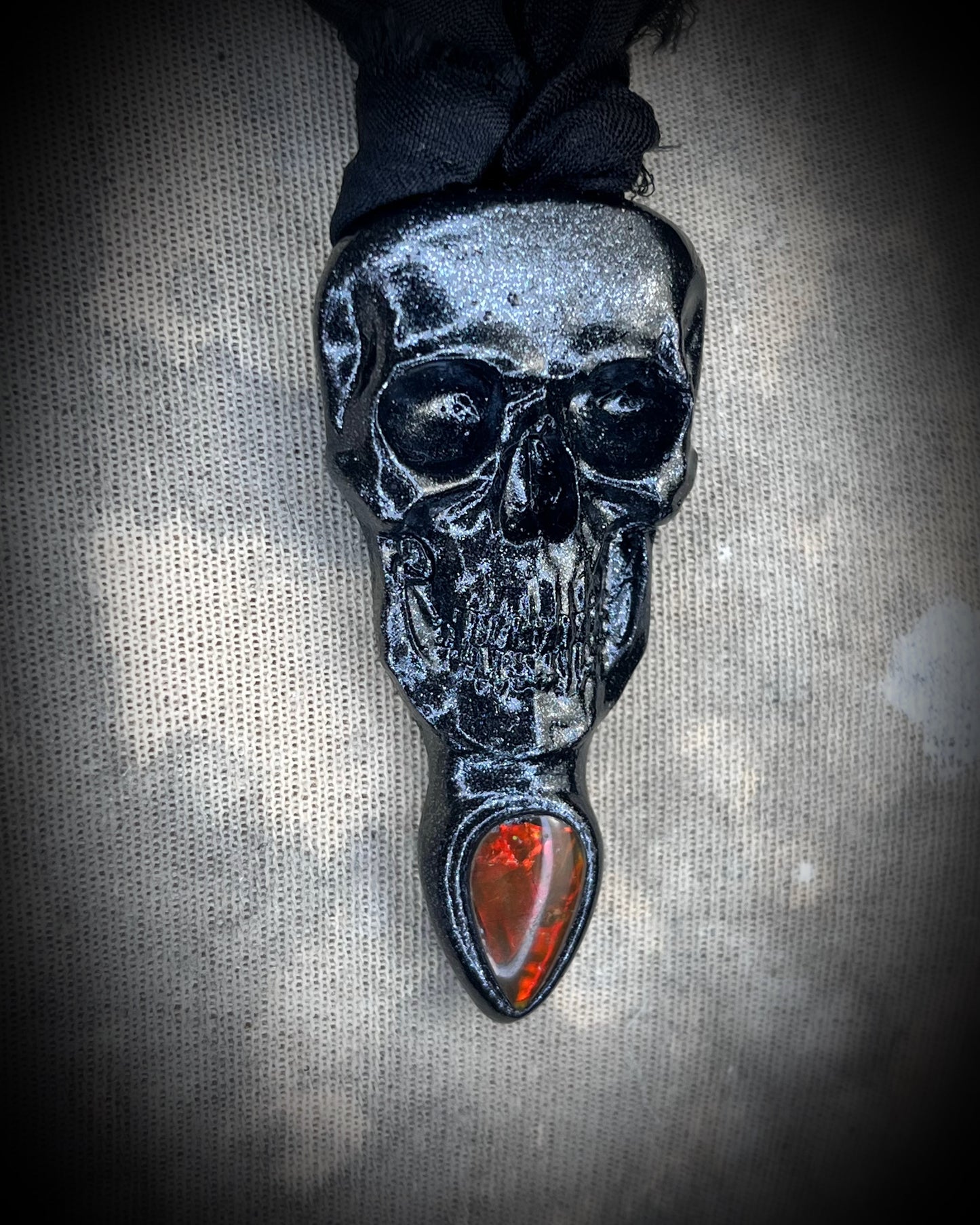 Black skull and red opalized ammolite gem necklace on black recycled silk. Macabre gothic jewelry for her, halloween gemstone jewelry for fall 2025 gift for him.