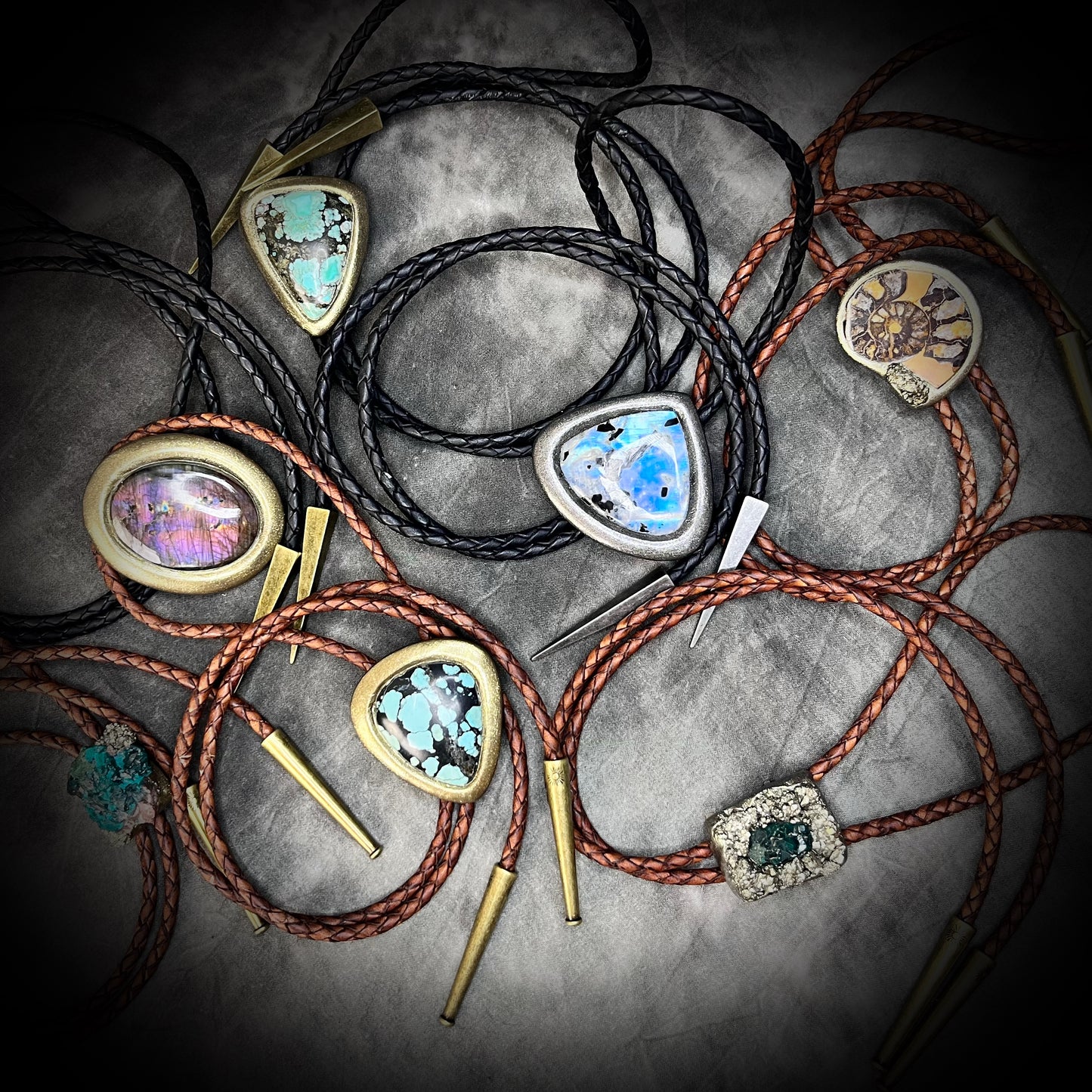 An array of handmade crystal bolo ties for him or her. Black and brown leather bolo ties featuring crystal healing gemstones, fossils and spiritual energy.