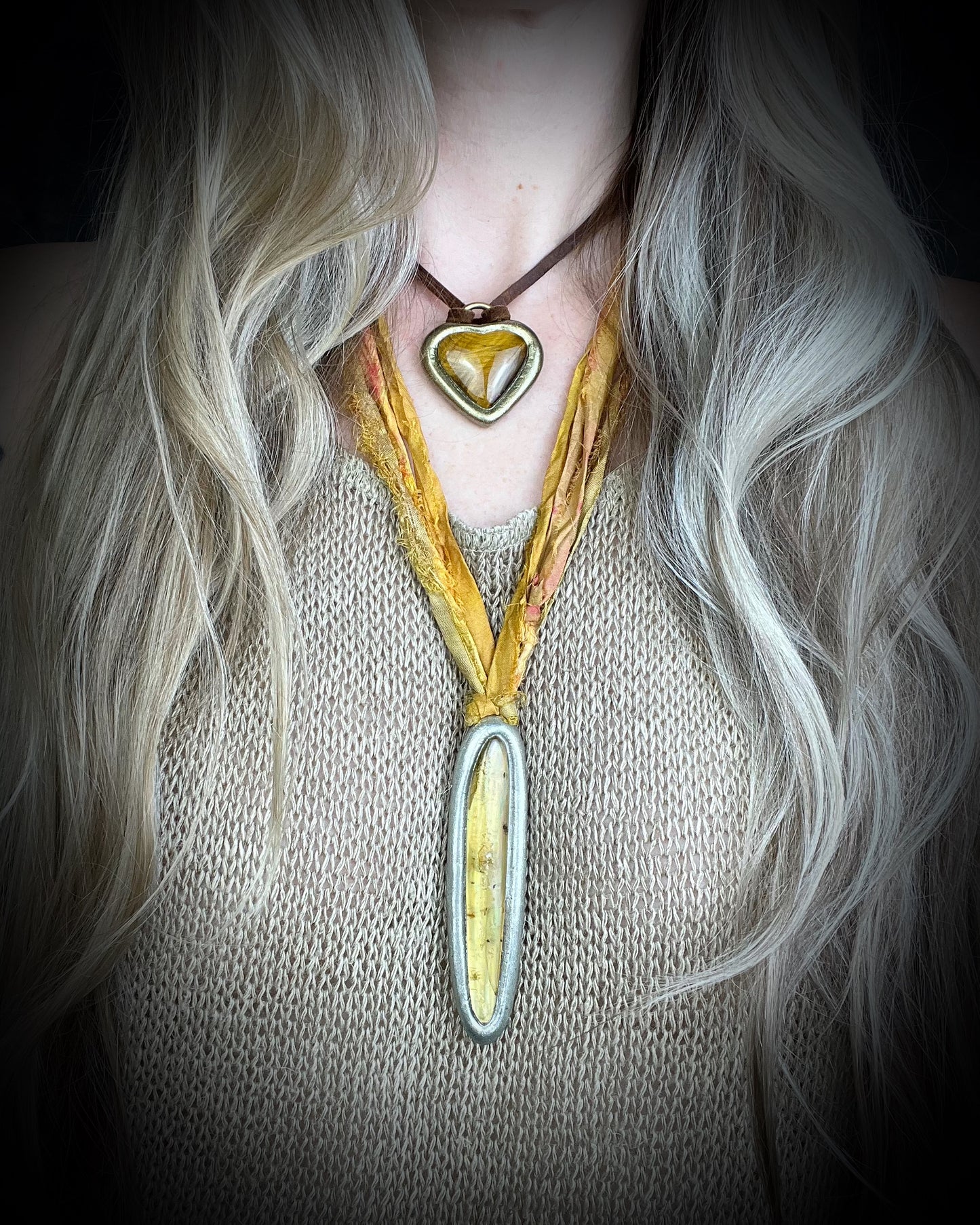 Model wearing layering necklaces including ancient insect included amber pendant in silver finish on marigold and yellow recycled silks. Enchanting natural history holiday gift for her!