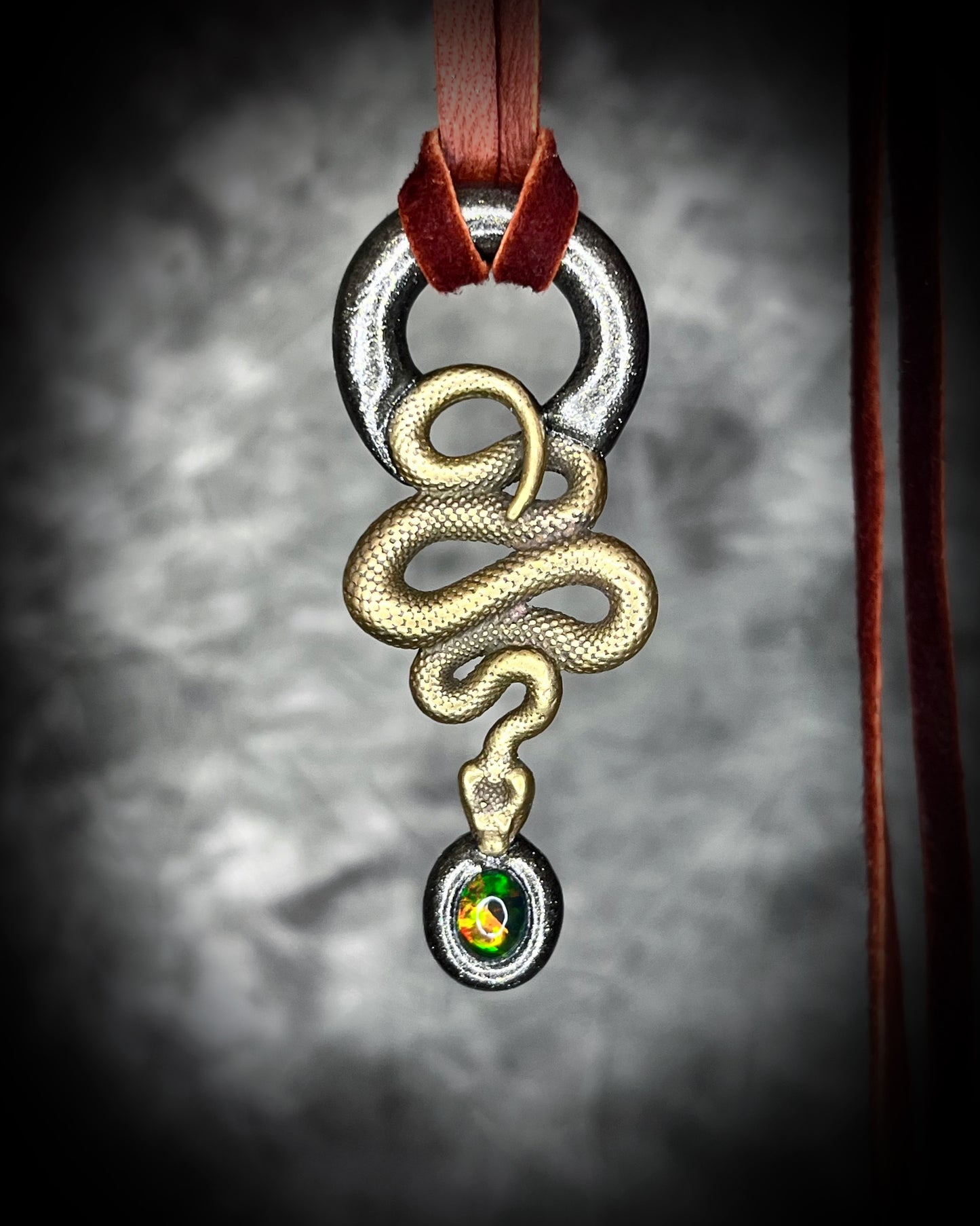 Artisan black opal and brass snake necklace, gothic witch jewelry symbolizing transformation, creativity, and magical protection.