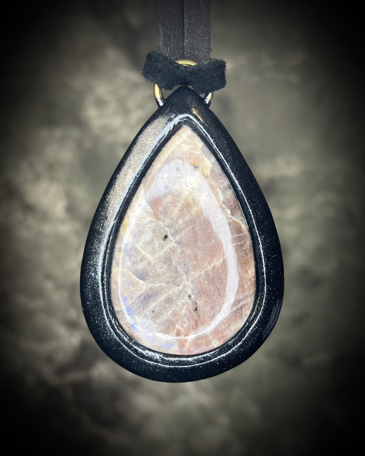 Belomorite sunstone moonstone teardrop pendant with shimmering feldspar color in a sculptural black-finish setting on black leather, handmade by Become Spellbound in Baltimore, Maryland.