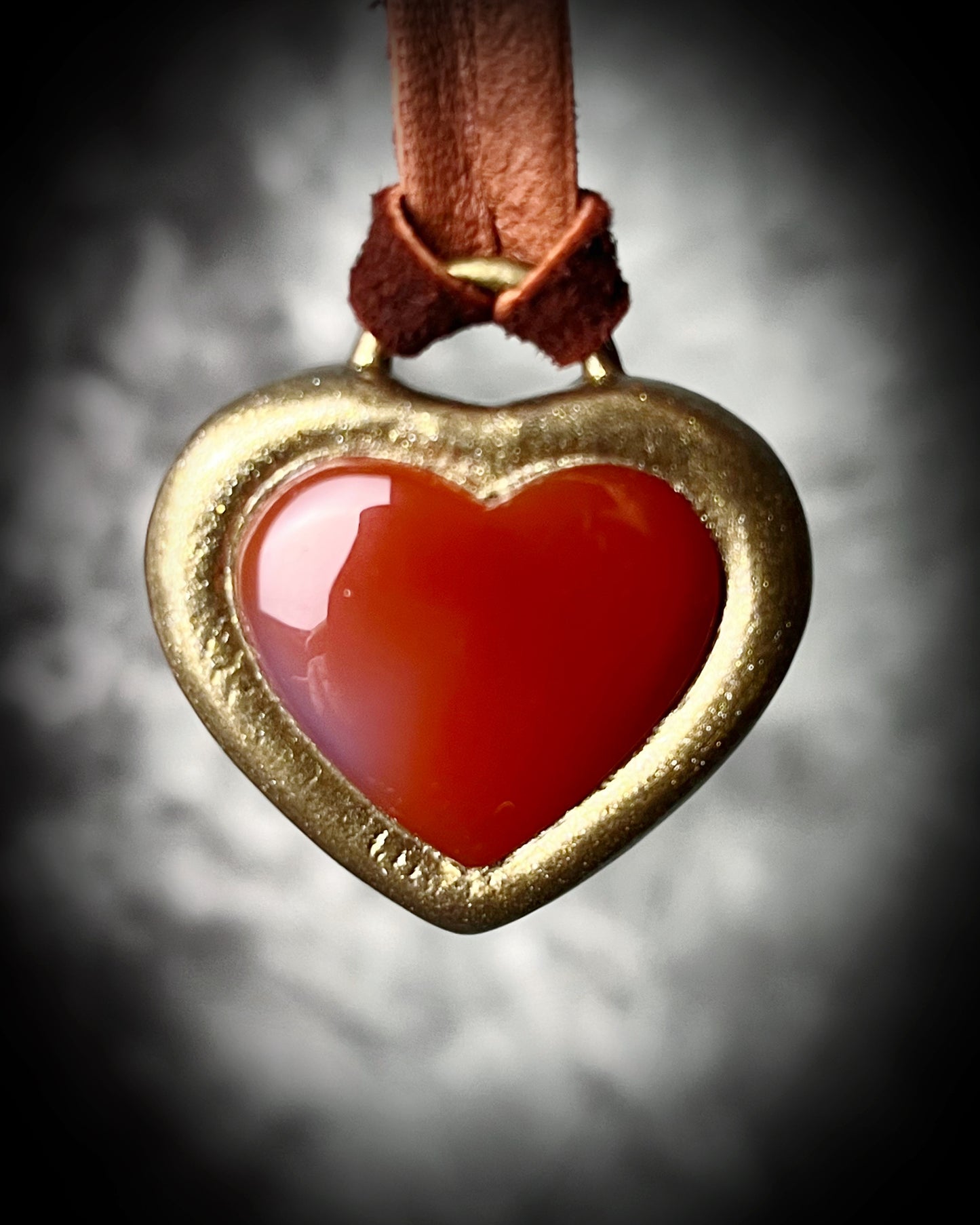 Bold Carnelian heart crystal pendant on dark brown leather cord, mystical autumn jewelry for grounding energy, strength, and warm bohemian vibes.