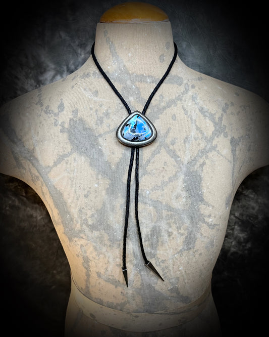 Crystal bolo tie styled as statement necklace on neutral male model. Rainbow moonstone teardrop shaped gunmetal silver finish bolo tie for him or her.