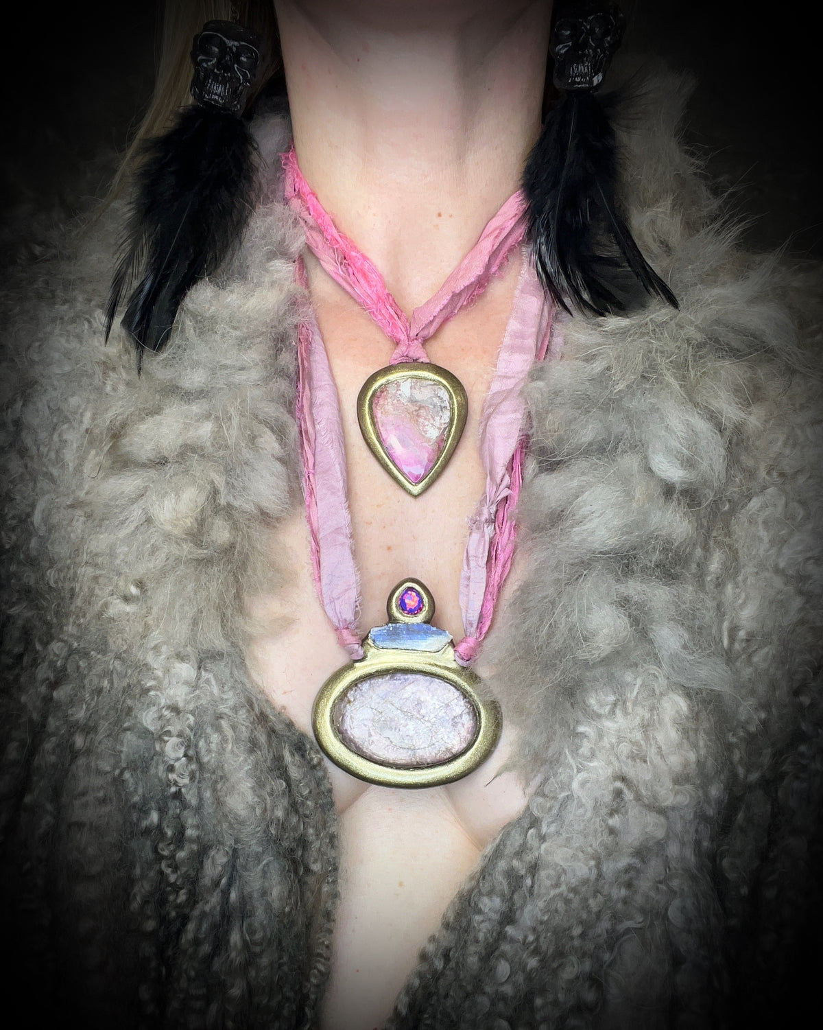 Gem lepidolite crystal talisman accented with blue kyanite and pink zircon in a sculptural gold-finish setting on pink recycled silk cords, handmade by Become Spellbound in Baltimore, Maryland.