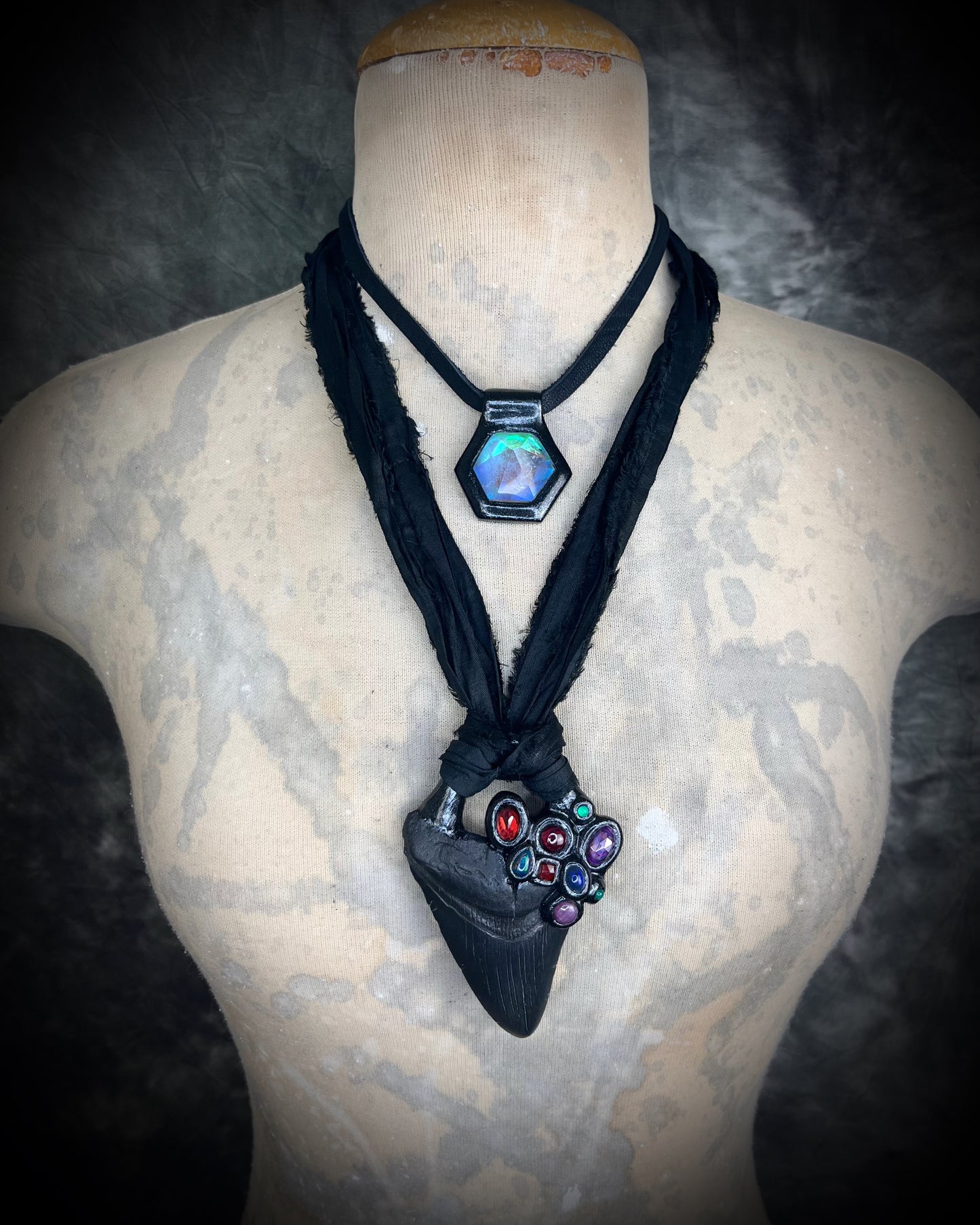 Dark Queen inspired handmade gemstone encrusted megalodon fossil tooth necklace. This talisman serves to ground and protect and would be at home on a fantasy film set or a birthday cosplay costume! Made in the USA on recycled silk for eco-friendly dark luxury.