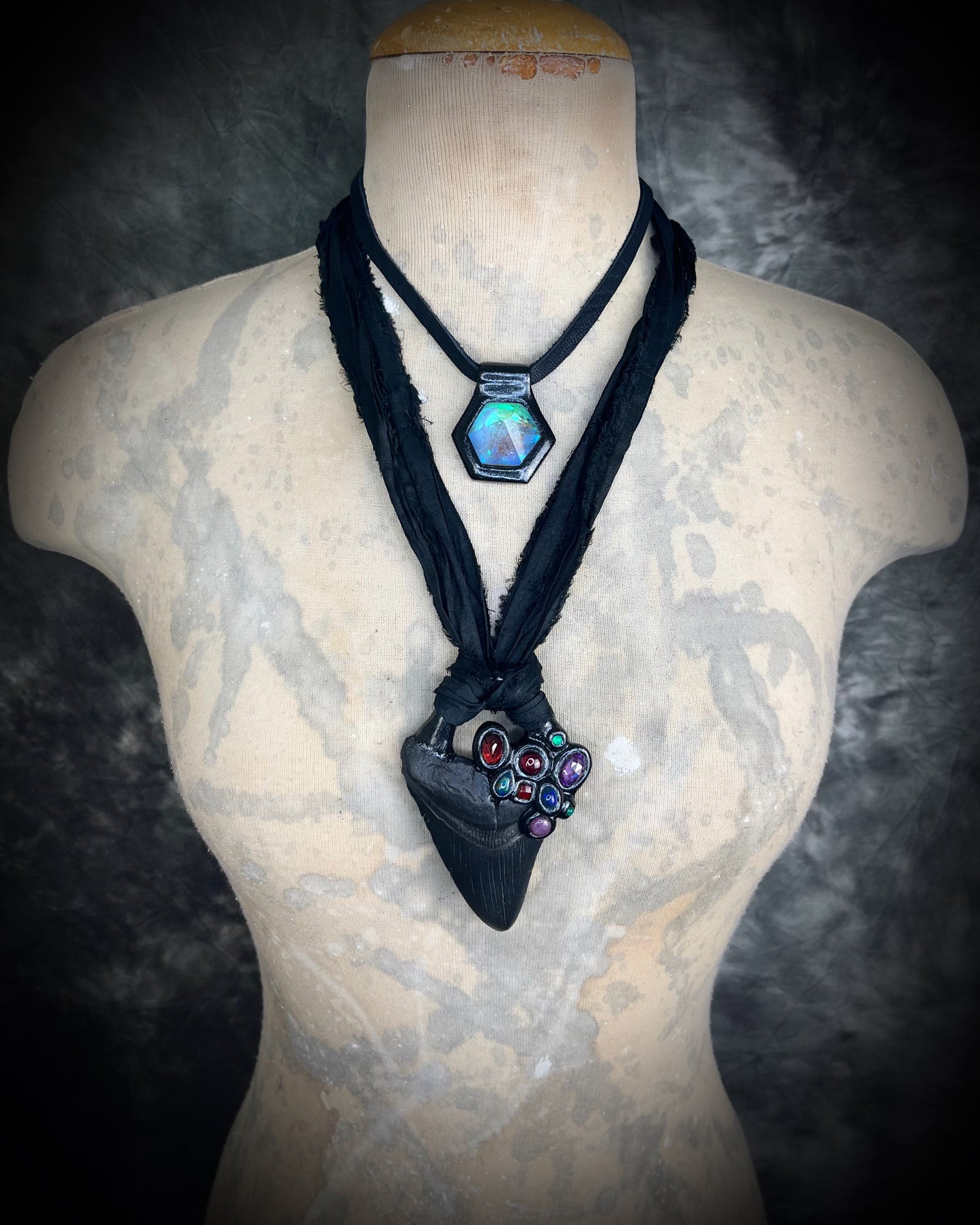 Dark Queen inspired handmade gemstone encrusted megalodon fossil tooth necklace. This talisman serves to ground and protect and would be at home on a fantasy film set or a birthday cosplay costume! Made in the USA on recycled silk for eco-friendly dark luxury.