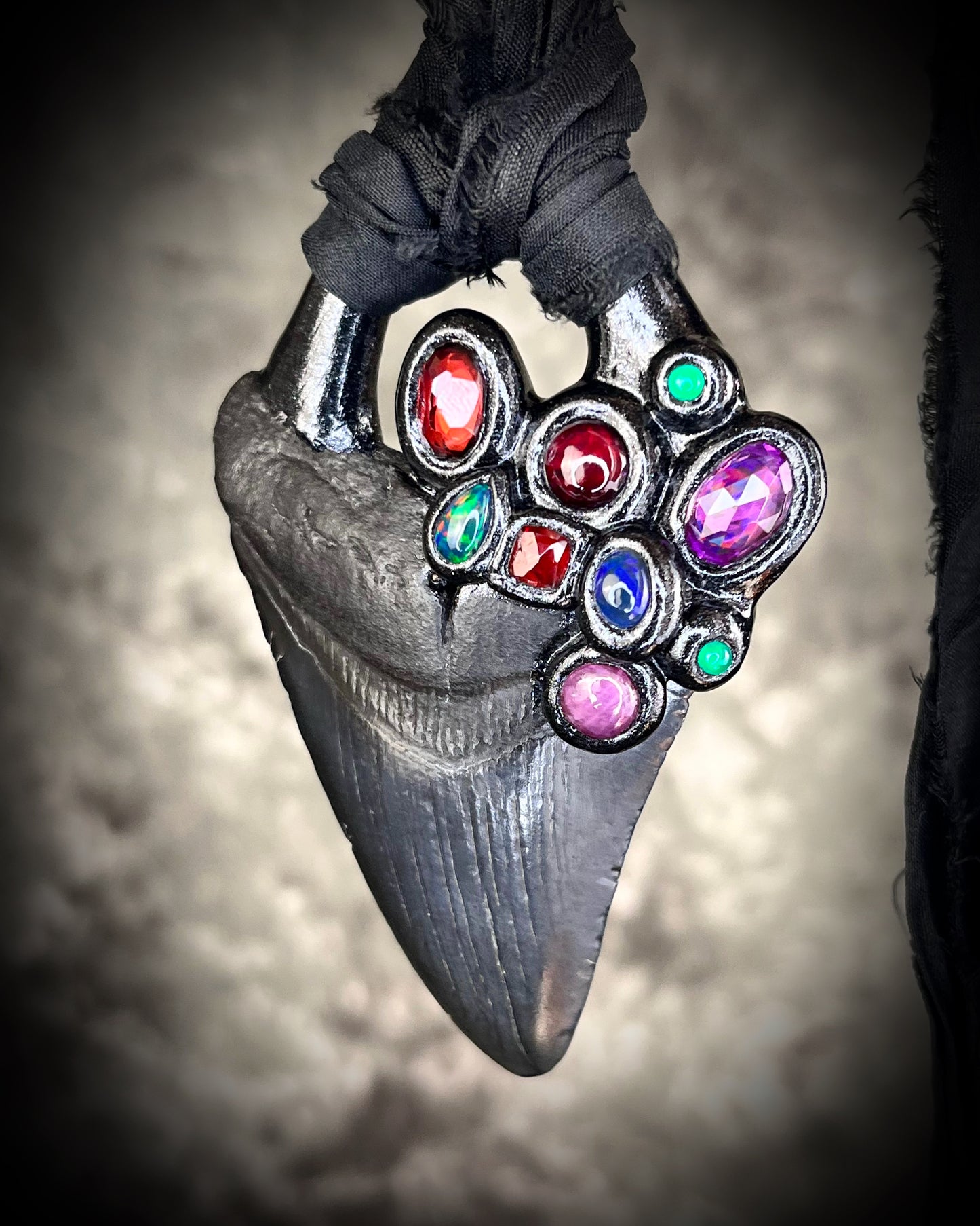 Dark Queen inspired handmade gemstone encrusted megalodon fossil tooth necklace. This talisman serves to ground and protect and would be at home on a fantasy film set or a birthday cosplay costume! Made in the USA on recycled silk for eco-friendly dark luxury.