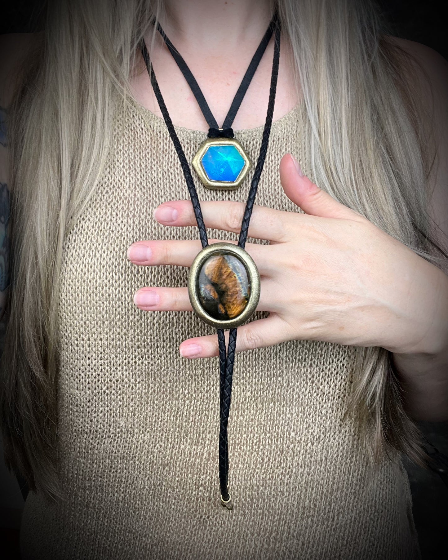 Glowing mystical orange labradorite bolo tie with blue stripe in a gold setting, black leather cord, and antique gold bolo tips. Handmade by Become Spellbound.