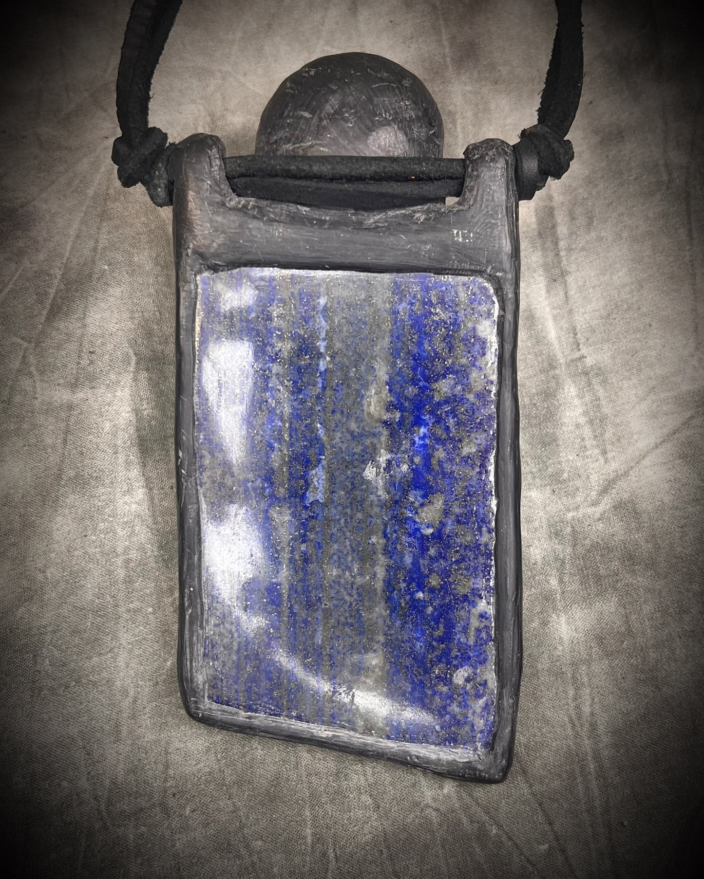 Handmade XL lapis lazuli slab necklace with bloodstone crystal skull, chrysocolla accents, black leather, handmade wire clasp, and bead detail by Anothai Hansen.