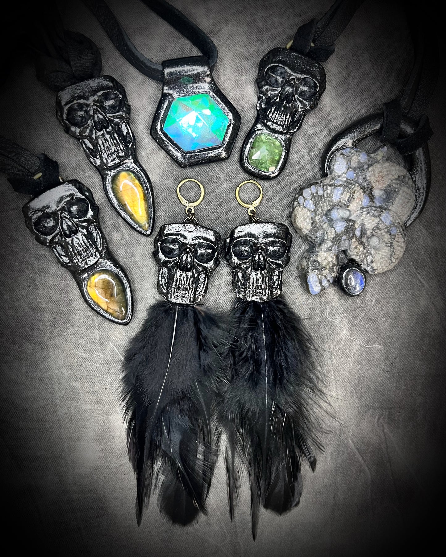 Handmade black skull and black feather earrings in a vintage inspired brass or sterling silver huggy earring style. Witchy and boho style meets gothic elegance.