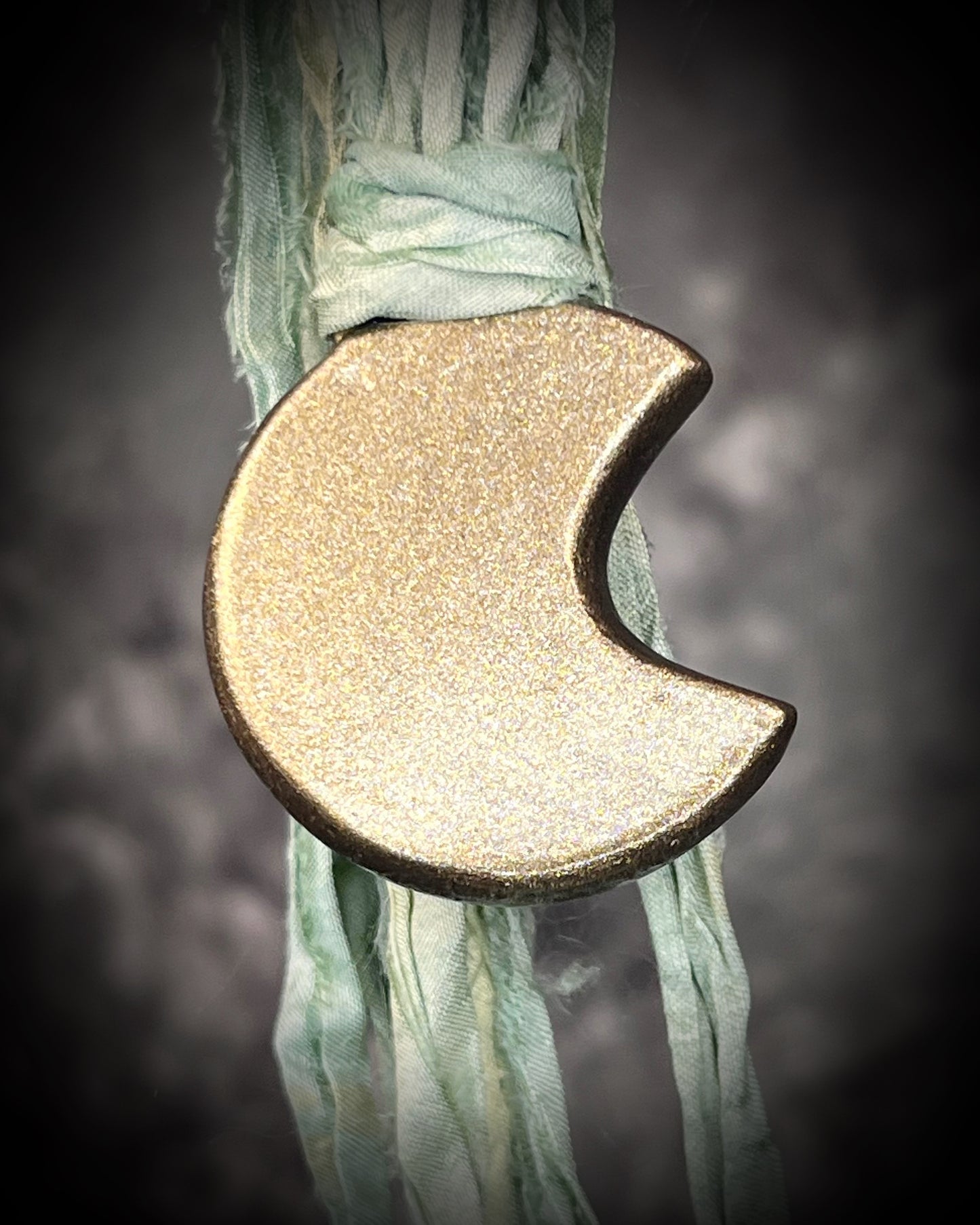 Labradorite moon talisman with high natural flash, sculpted gold finish, and aqua green recycled silk ties by Become Spellbound.