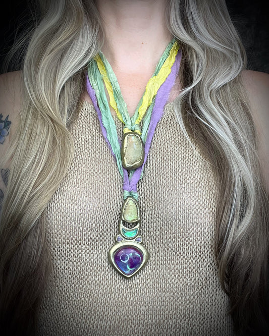 Libyan Desert Glass talisman with amethyst, prasiolite and lavender spinel on recycled silk, featuring shifting green, gold, pink and purple glow. Handmade by Become Spellbound.