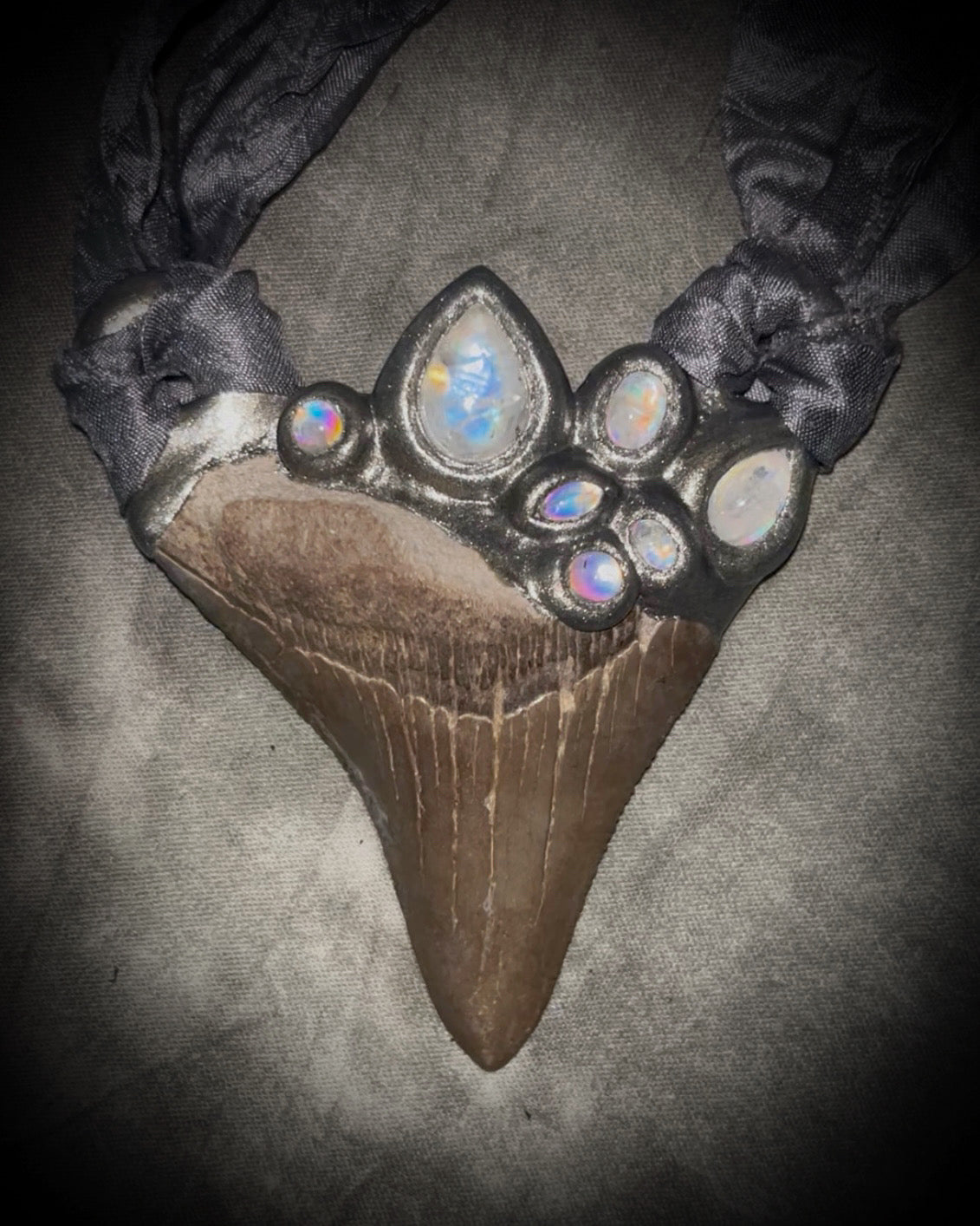 Megalodon shark tooth fossil handcrafted crystal talisman featuring rainbow moonstones in silver, hung from recycled slate gray silk. Beach wedding or beach photoshoot, cosplay, fantasy film costume or everyday enchantment!