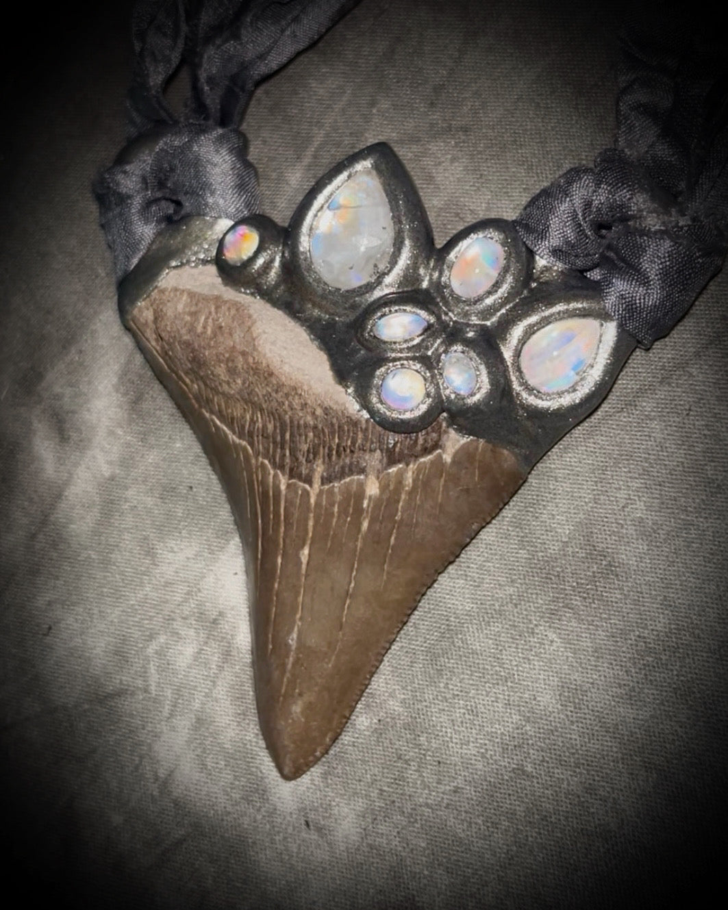 Megalodon shark tooth fossil handcrafted crystal talisman featuring rainbow moonstones in silver, hung from recycled slate gray silk. Beach wedding or beach photoshoot, cosplay, fantasy film costume or everyday enchantment!