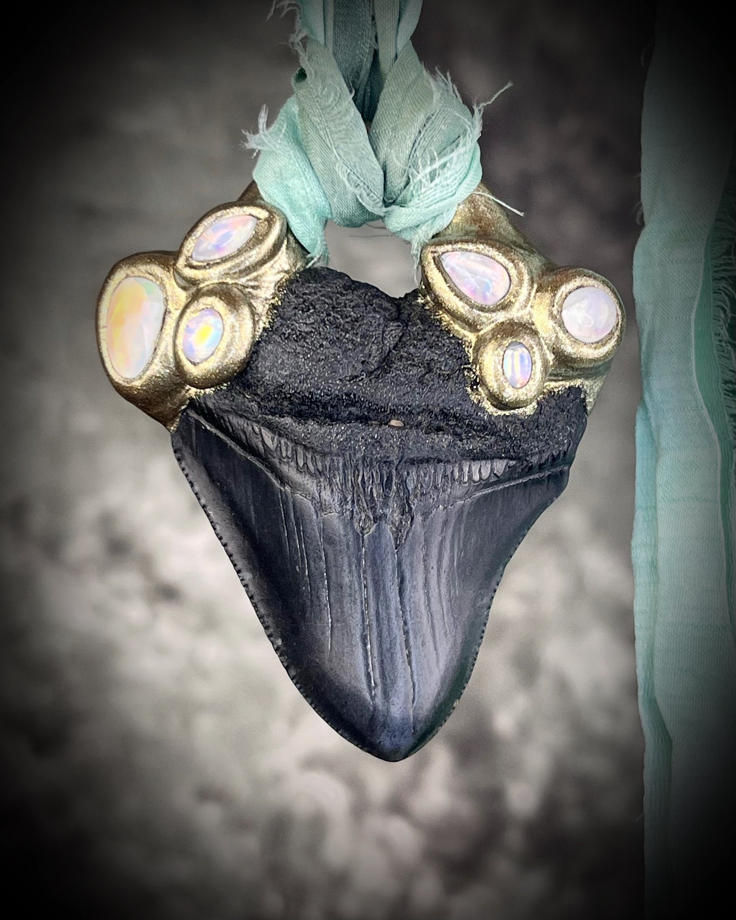 Megalodon shark tooth fossil handcrafted crystal talisman featuring opal gemstone and rainbow moonstones in gold, hung from recycled aqua silk. Beach wedding or summer jewelry photoshoot, cosplay, fantasy film costume or everyday enchantment!