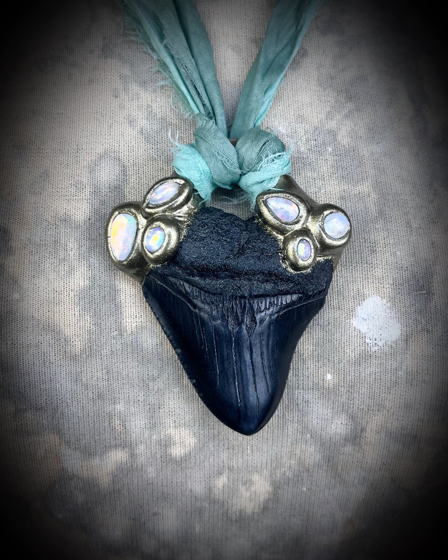 Megalodon shark tooth fossil handcrafted crystal talisman featuring opal gemstone and rainbow moonstones in gold, hung from recycled aqua silk. Beach wedding or summer jewelry photoshoot, cosplay, fantasy film costume or everyday enchantment!
