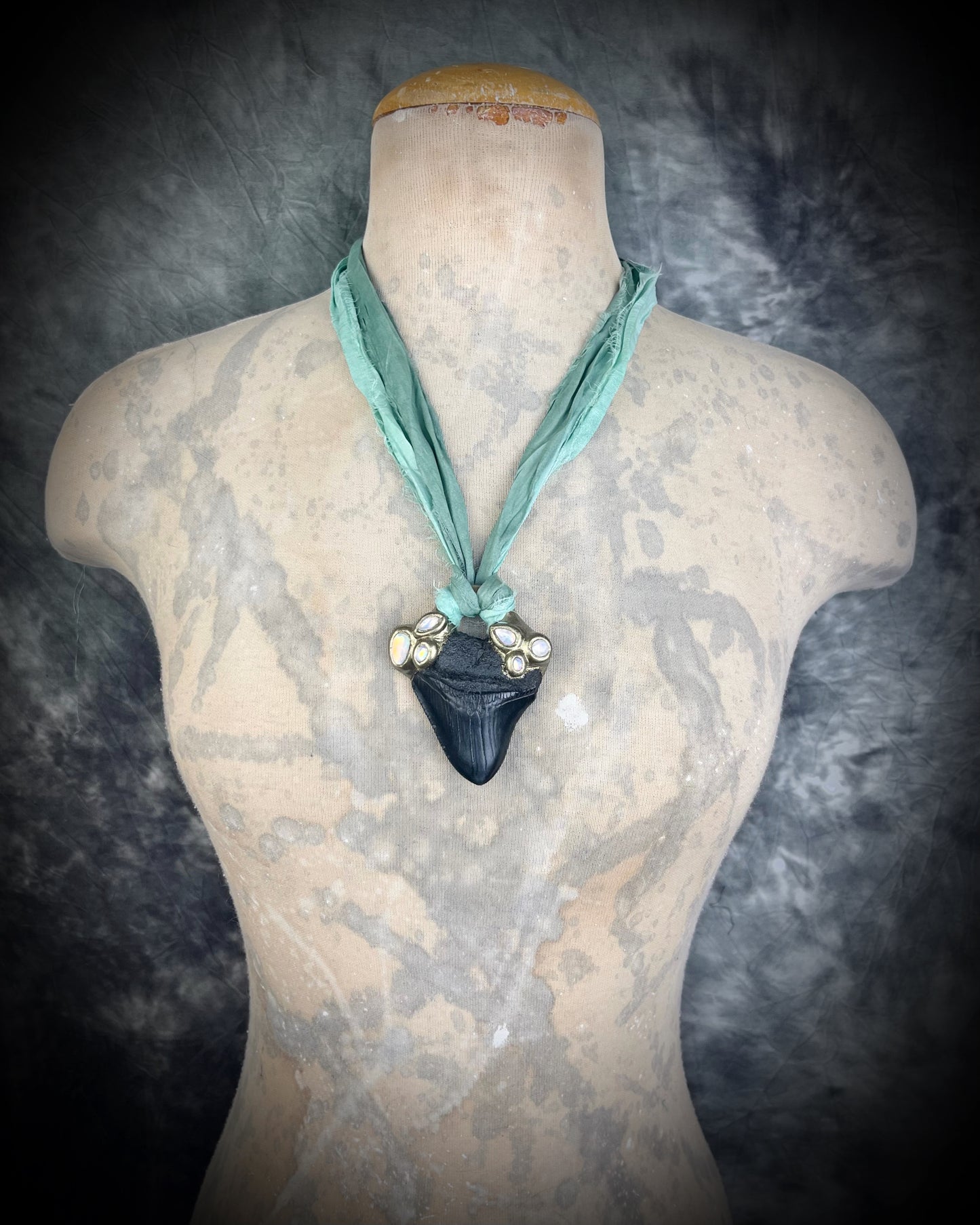 Megalodon shark tooth fossil handcrafted crystal talisman featuring opal gemstone and rainbow moonstones in gold, hung from recycled aqua silk. Beach wedding or summer jewelry photoshoot, cosplay, fantasy film costume or everyday enchantment!