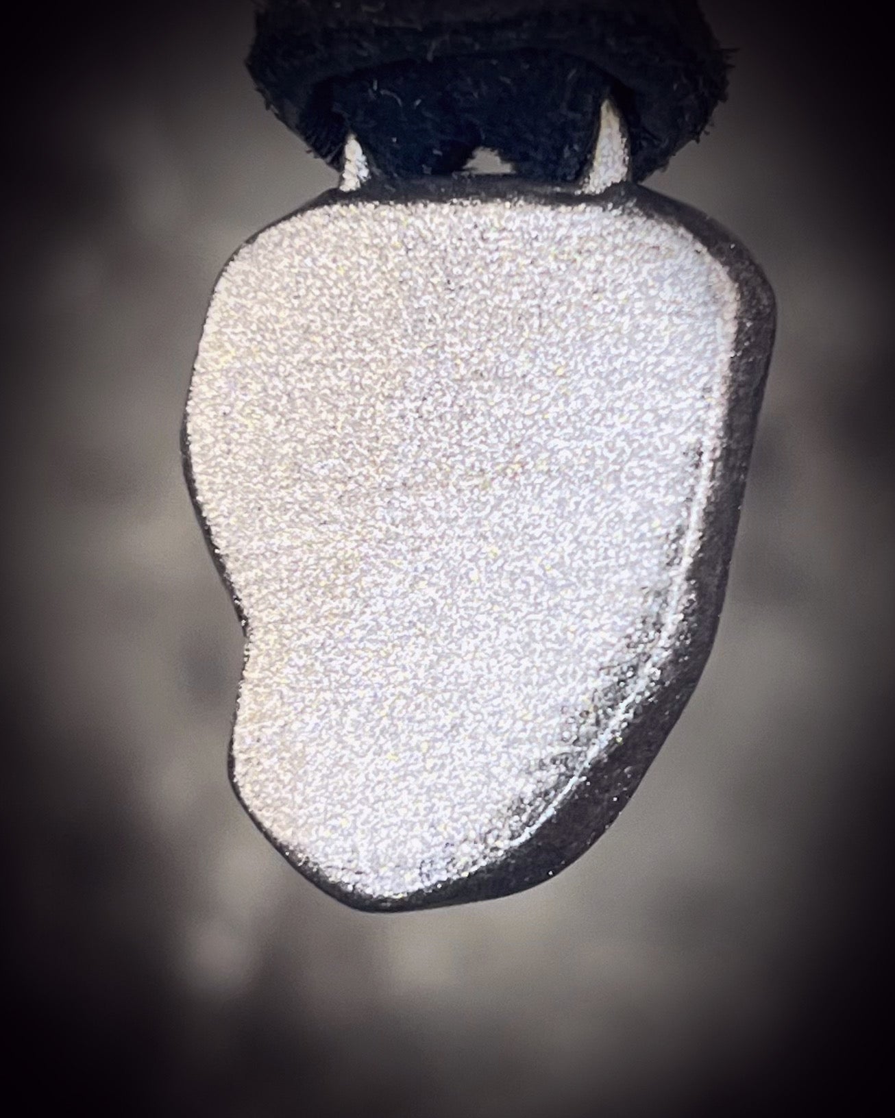 Meteorite talisman in gunmetal finish on black leather, cosmic statement jewelry handmade by Become Spellbound in Baltimore, Maryland.