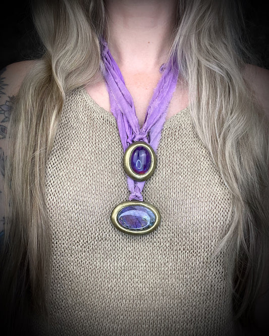 Mystical amethyst talisman with soft nebula glow, sculpted gold finish, and lilac recycled silk ties by Become Spellbound.