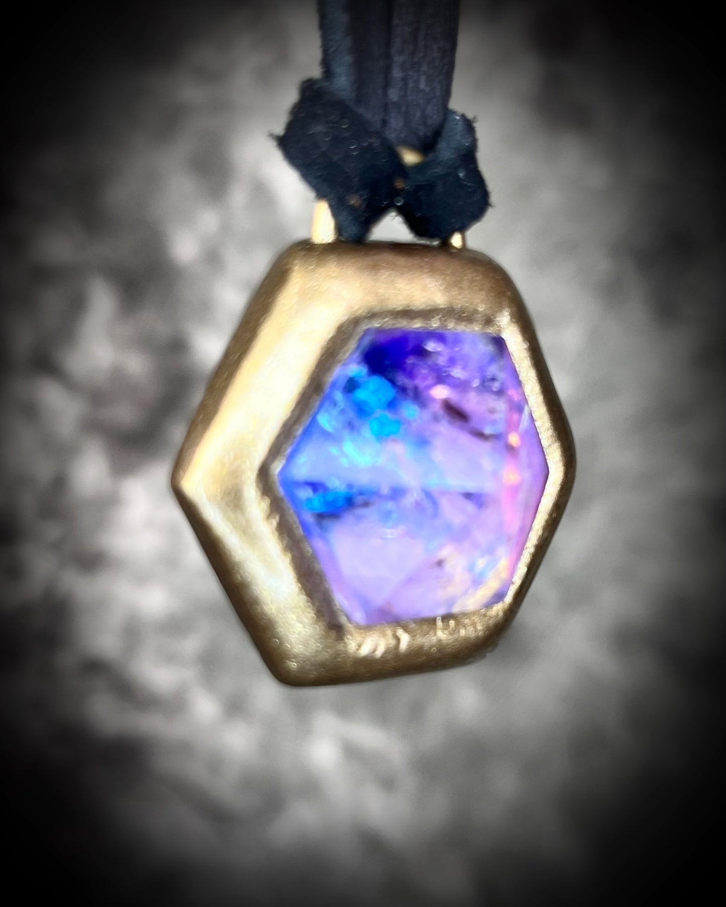 Opalescent amethyst hexagon pendant framed in gold on black leather cord — handmade mystical crystal talisman necklace.