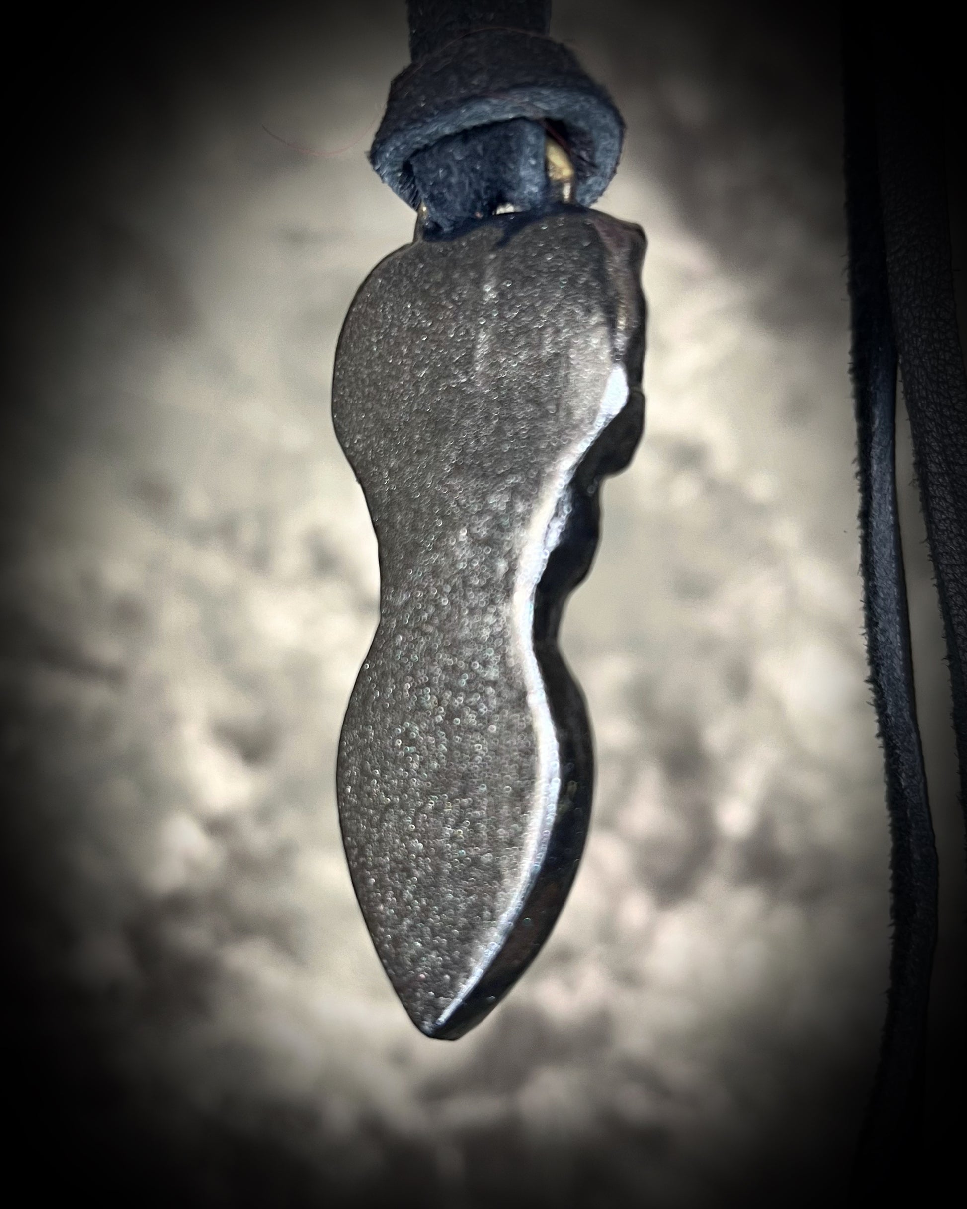 Skull-shaped pendant with a yellow fire citrine teardrop shaped gemstone on a dark background. Halloween jewelry for her, gothic jewelry gift for her.