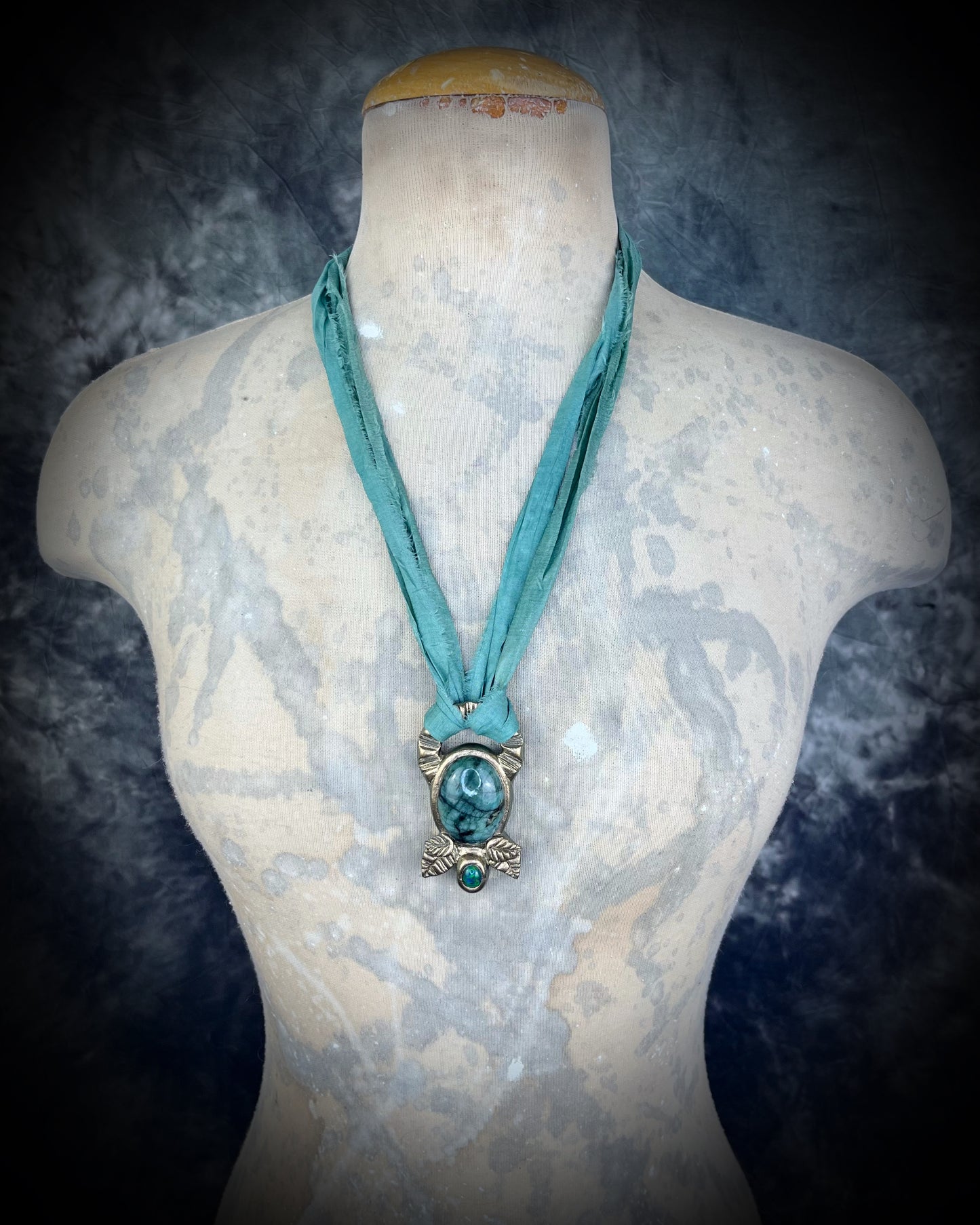Emerald and black opal gemstone necklace in a luxe gold setting, crafted on aqua recycled silk. One-of-a-kind crystal healing pendant, sustainable and perfect for 2025 gifting.