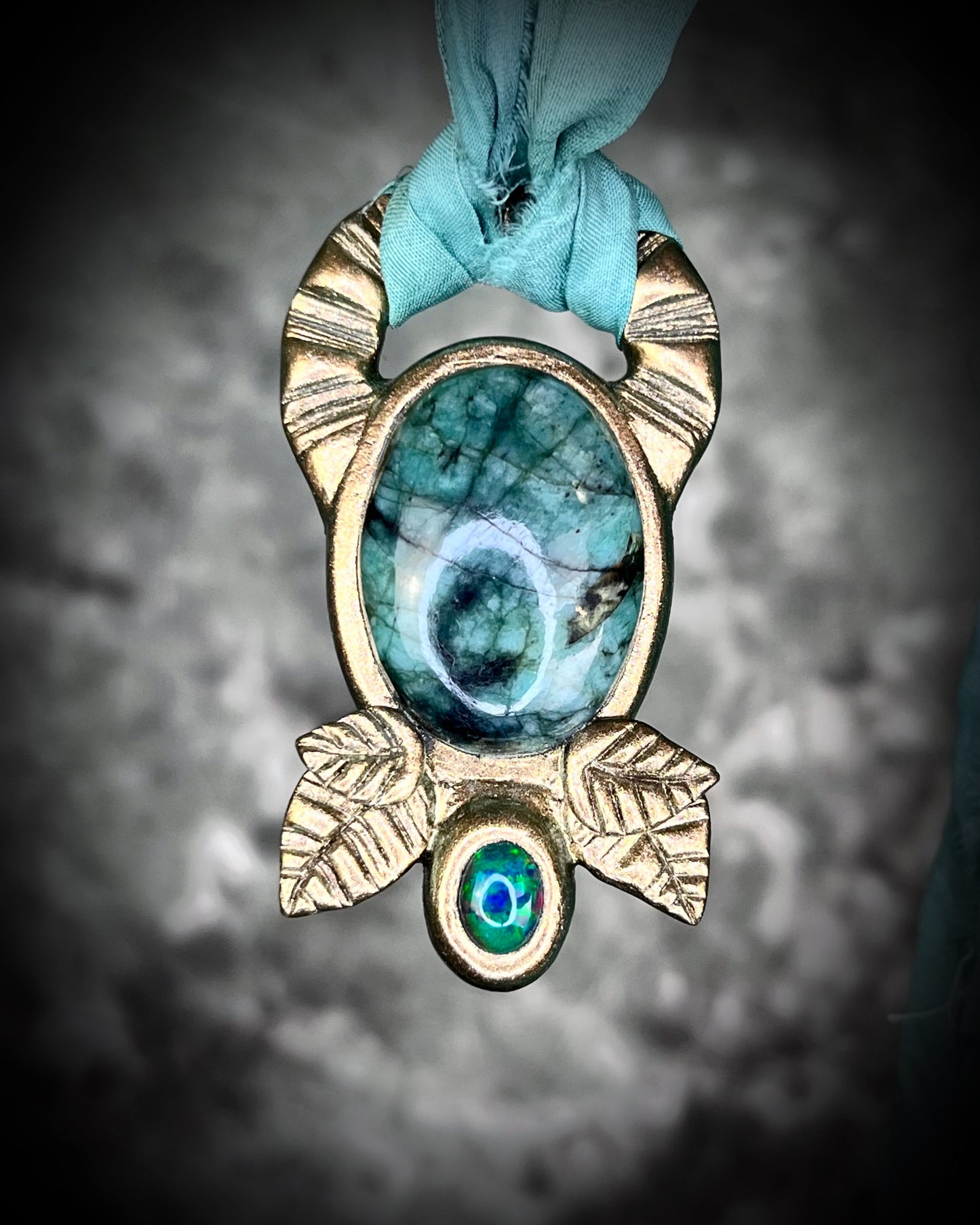 Emerald and black opal gemstone necklace in a luxe gold setting, crafted on aqua recycled silk. One-of-a-kind crystal healing pendant, sustainable and perfect for 2025 gifting.