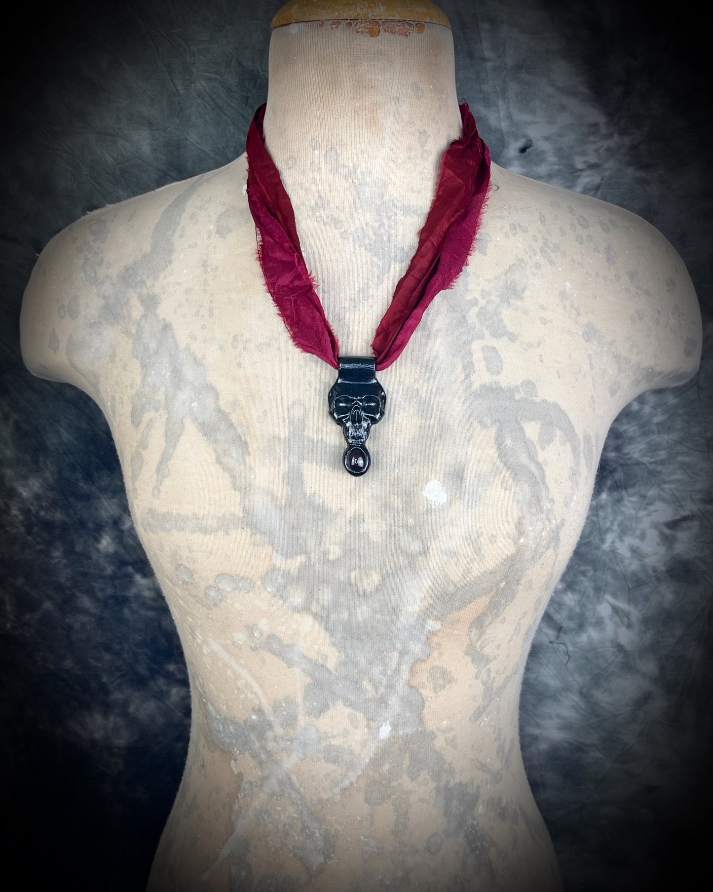 Handmade sculptural skull and natural garnet crystal talisman. Pendant gift for her, hung from red recycled silk for a gothic elegance.