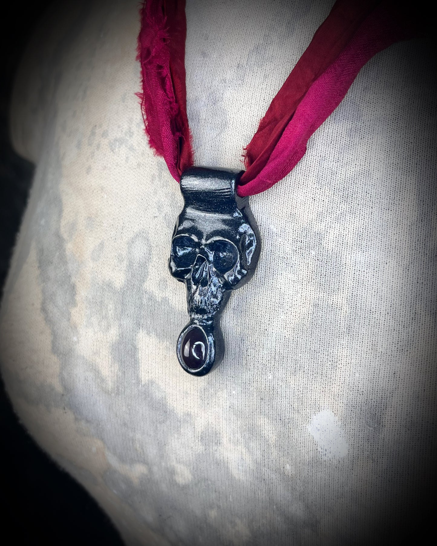 Handmade sculptural skull and natural garnet crystal talisman. Pendant gift for her, hung from red recycled silk for a gothic elegance.