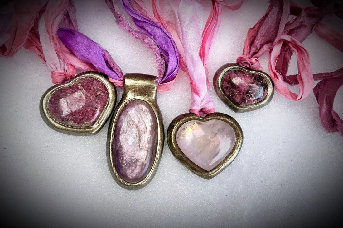 Crystal heart necklaces and an oval lepidolite necklace in gold finishes all hung from pink and lilac recycled silks for Valentine's day gifting