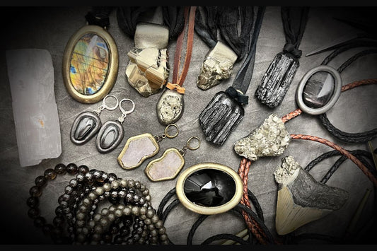 Flat lay of various protection crystal necklaces, bracelets and earrings to ward off energy vampires and ground your energy
