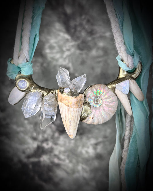 Fantasy film inspired goddess warrior collar featuring a genuine cave bear tooth fossil, naturally shed deer antler, ammonite rainbow fossil, moonstone crystal and more, hung from recycled silk for eco-friendly adventures.  