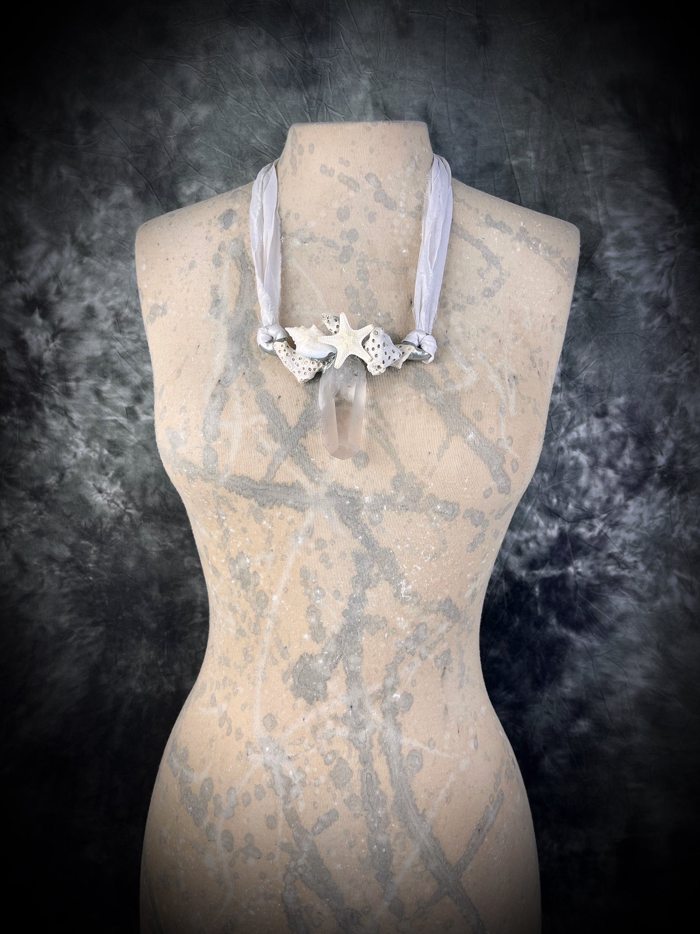 Handmade designer bridal or beach bride necklace featuring a silver finish, quartz crystal, white fossilized coral, starfish, seashell and is strung from recycled white silk for an eco-friendly summer beach wedding elegance.  Can customizable to be worn short as a choker to long.