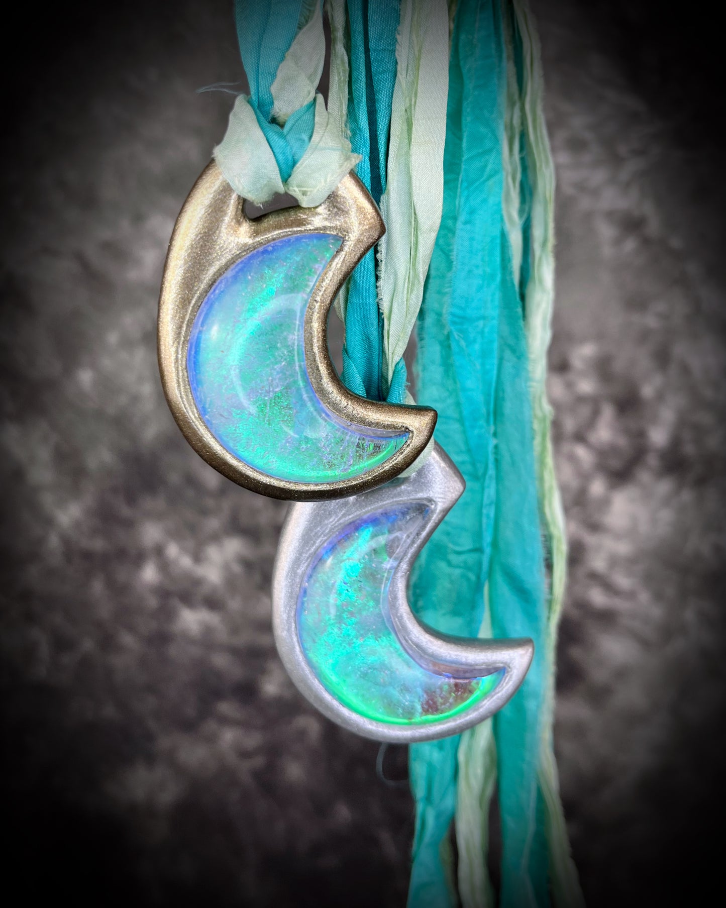 Handmade designer green turquoise opalescent quartz gemstone crescent moon pendants in a silver and gold finish.  This crystal healing necklace is strung from aqua and mint green recycled silk for the eco-friendly jewelry collector.  