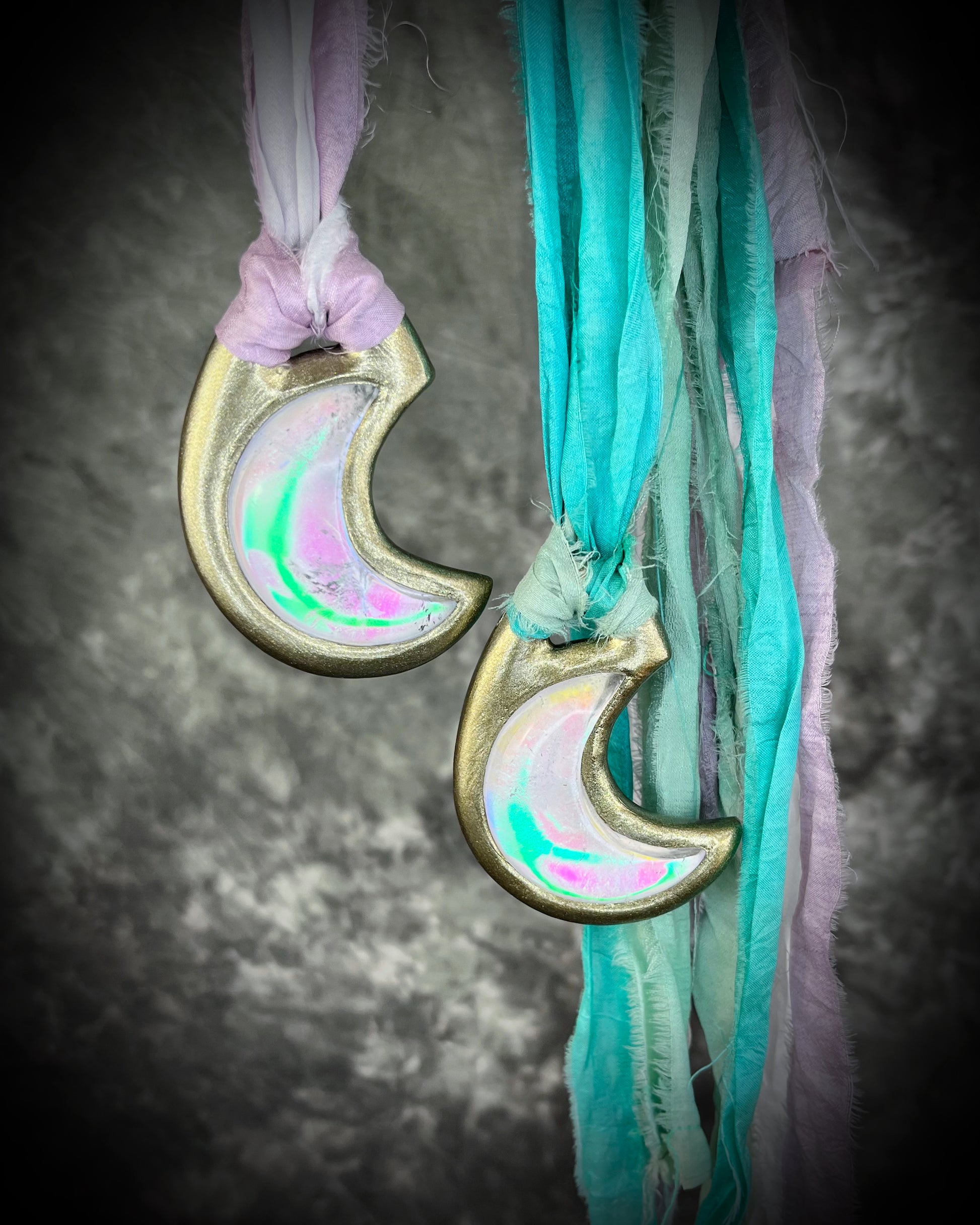 Handmade designer pink and green opalescent quartz gemstone crescent moon pendants in a silver and gold finish.  These crystal healing necklaces are strung from lilac, white, turquoise and mint green recycled silk for the sustainable bride or jewelry collector.