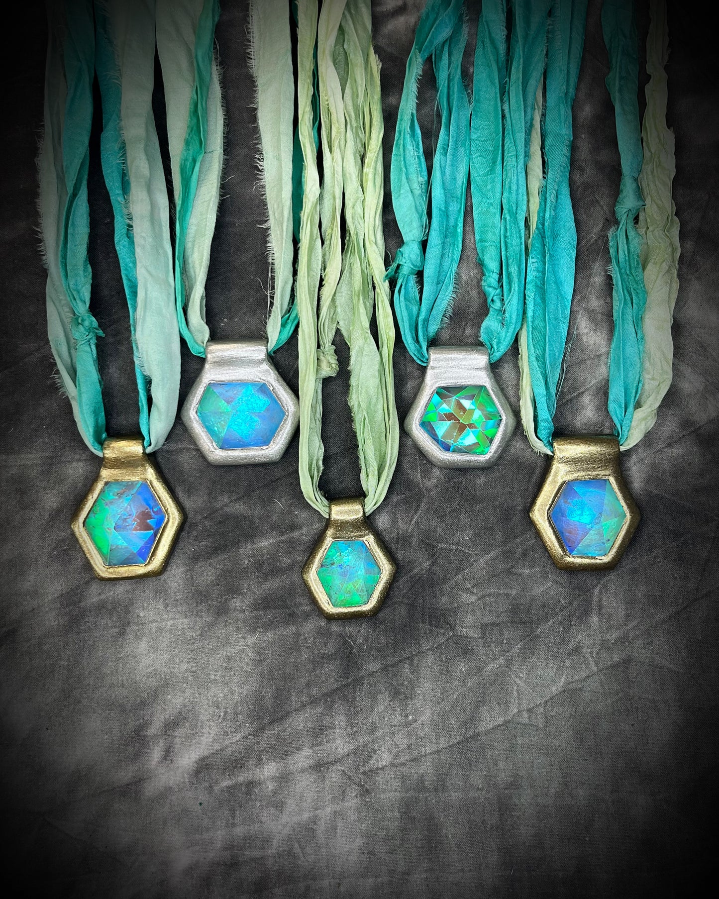 Various handmade designer aqua turquoise opalescent quartz gemstone pendants in a gold and silver finish.  These crystal healing necklaces are customizable and can be strung from leather or sea green recycled silk for the sustainable and eco-friendly jewelry lover or mermaid.