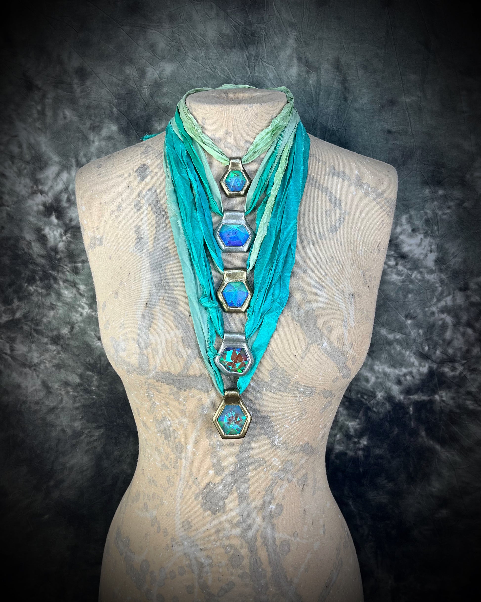 Mannequin layering various handmade designer aqua turquoise opalescent quartz gemstone pendants in a gold and silver finish.  These crystal healing necklaces are customizable and can be worn short as a choker or long for any jewelry lover or mermaid.