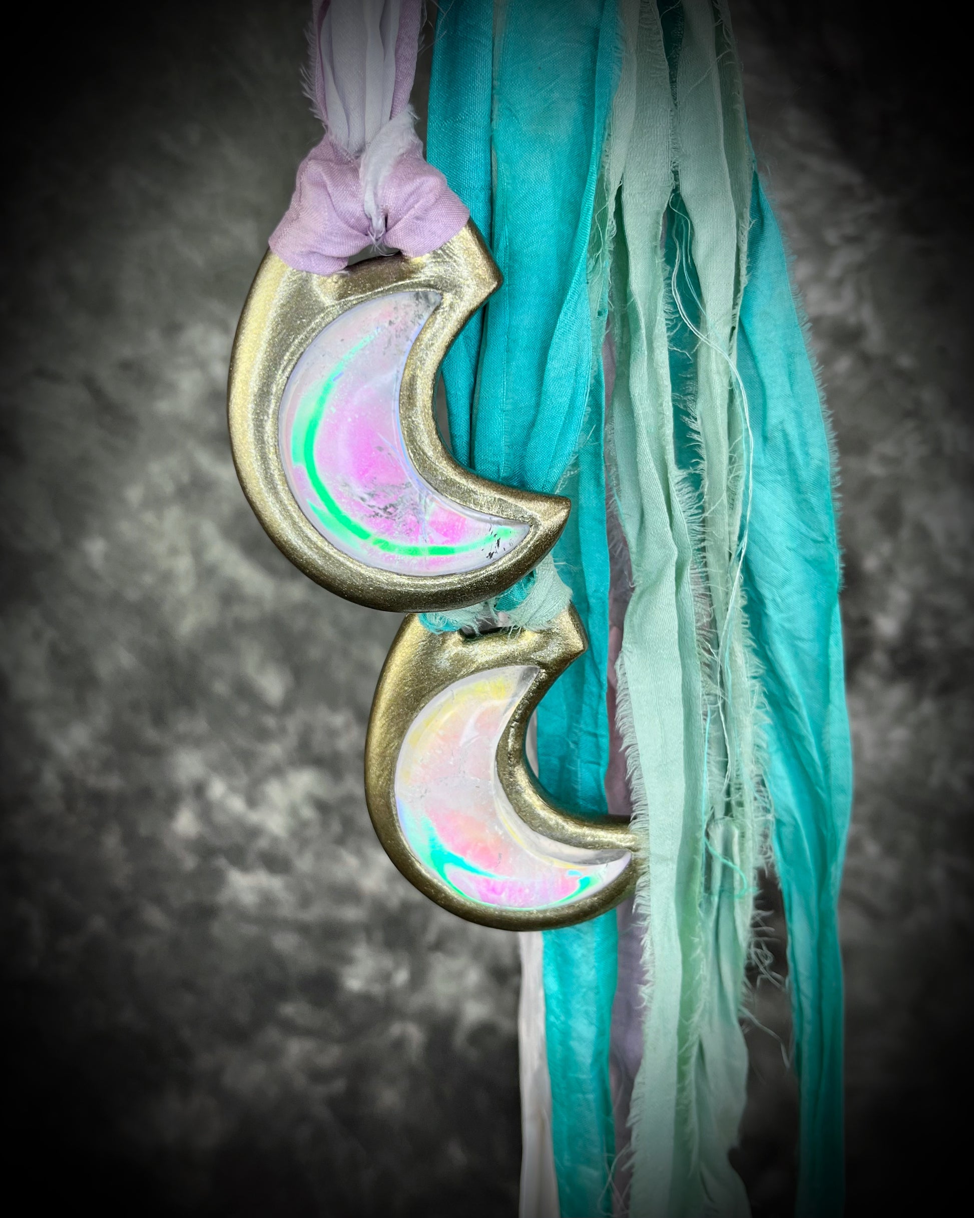 Handmade designer pink and green opalescent quartz gemstone crescent moon pendants in a silver and gold finish.  These crystal healing necklaces are strung from lilac, white, turquoise and mint green recycled silk for the sustainable bride or jewelry collector.