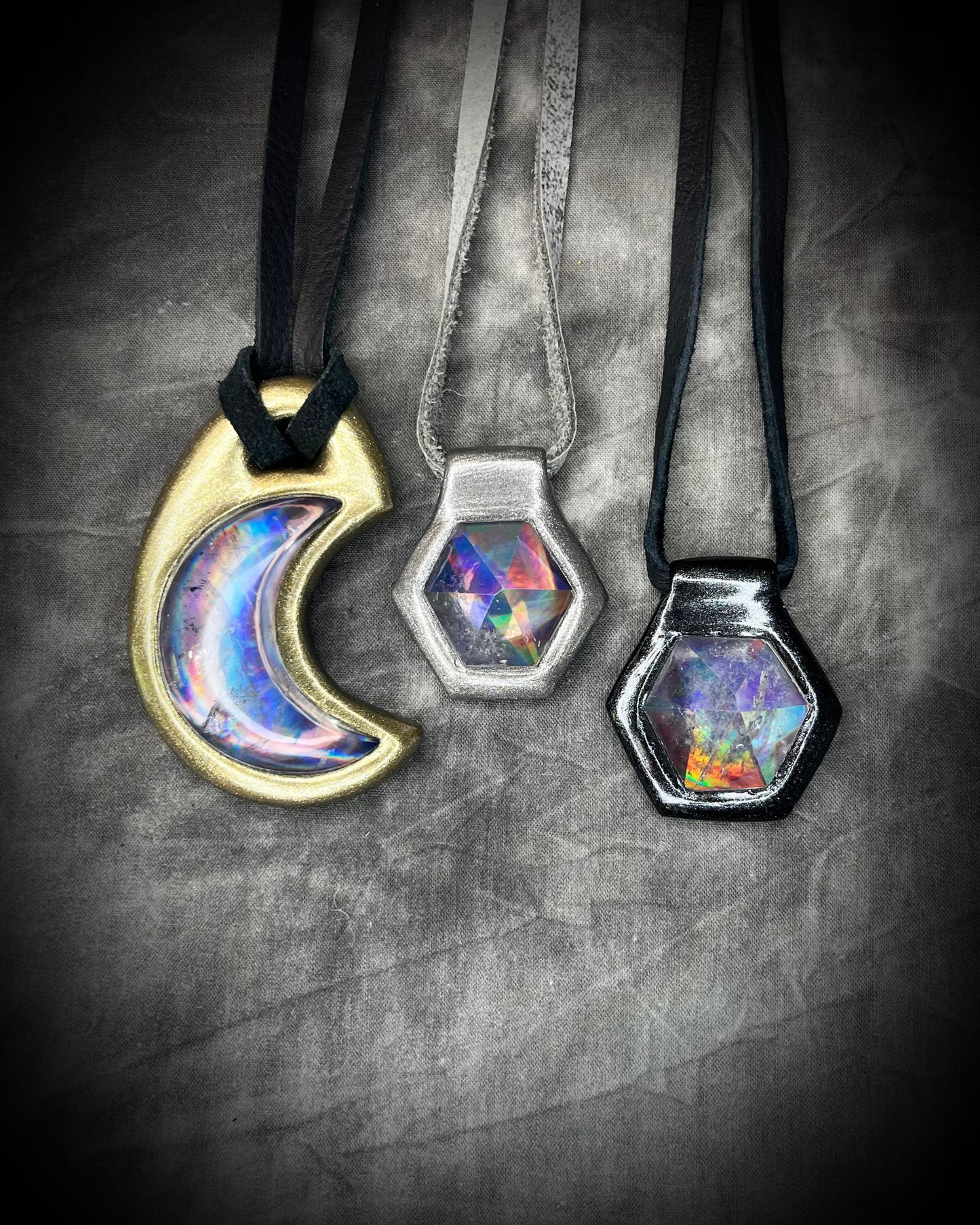 Silver and Black David Bowie inspired designer quartz black rainbow necklaces shown with gold finish Blaack Rainbow crescent moon necklace, on silver and black leather.