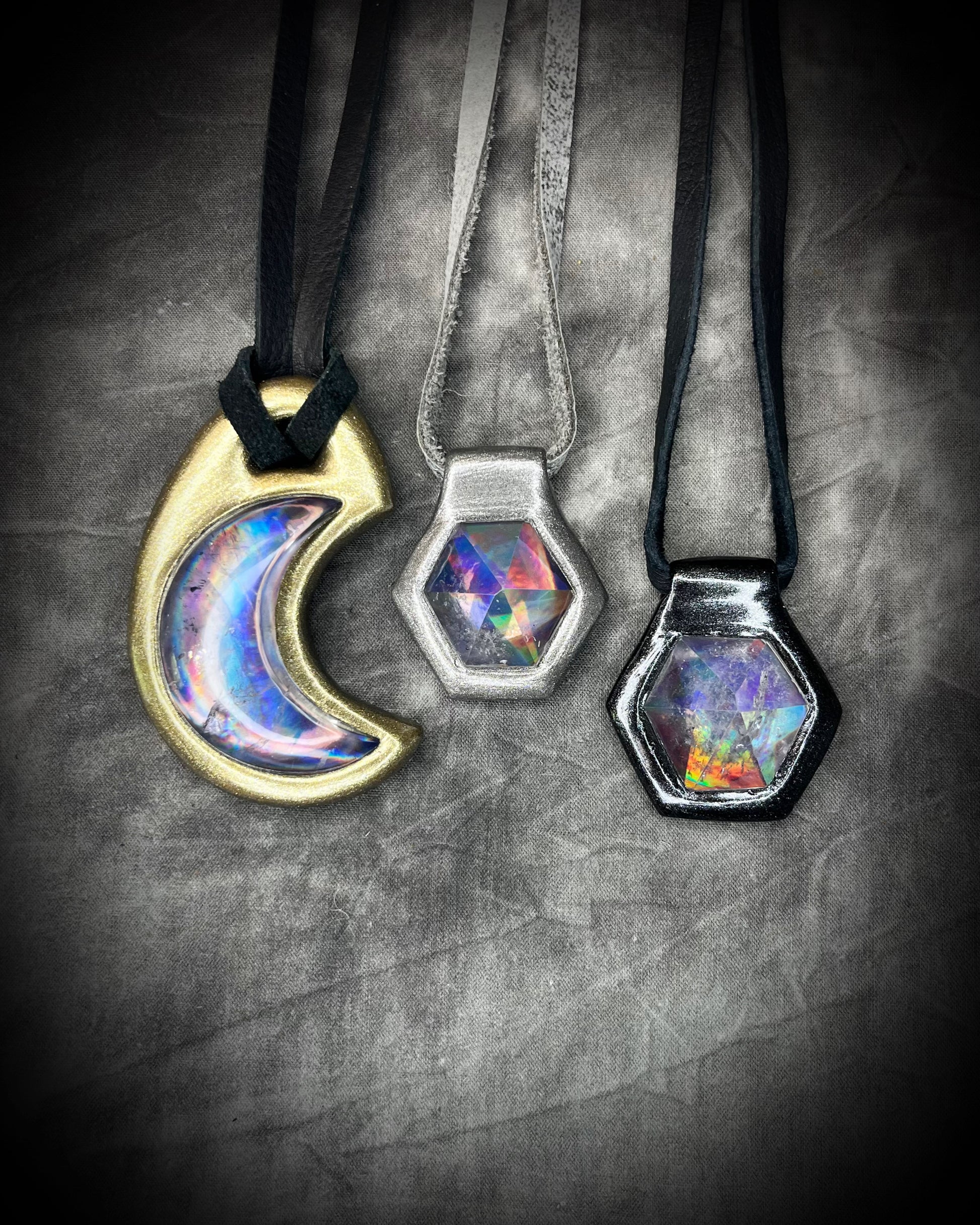 Silver and Black David Bowie inspired designer quartz black rainbow necklaces shown with gold finish Blaack Rainbow crescent moon necklace, on silver and black leather.