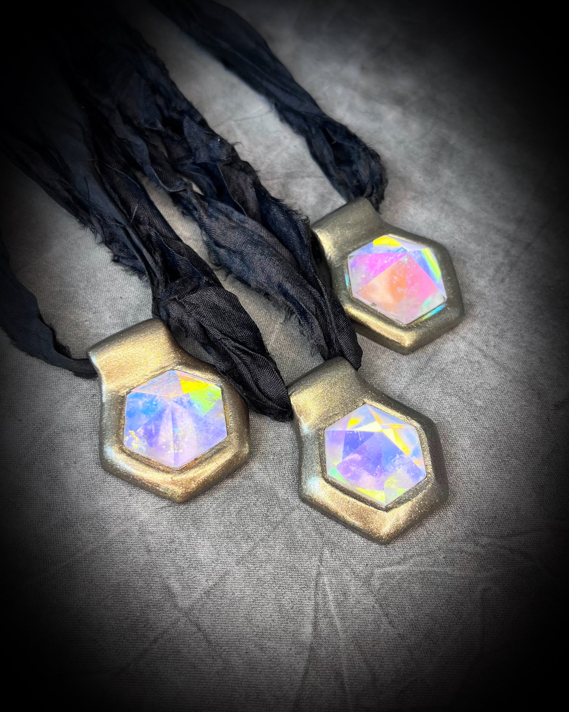 Handmade designer clear opalescent quartz gemstone pendants in a gold finish.  These crystal healing pyramid hexagon necklaces are strung from black recycled silk for the sustainable and eco-friendly jewelry lover, boho babe or modern mystic. 
