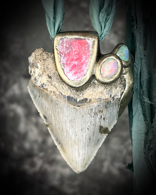 Necklace with a unique pendant featuring a pink stone and opal on a textured background