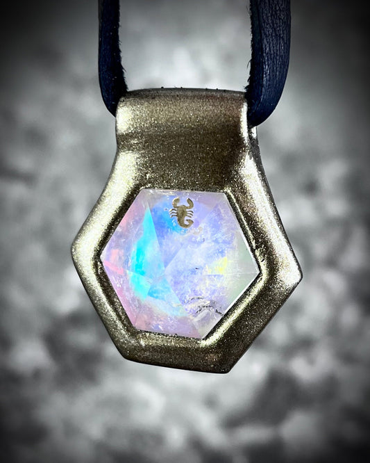 A gold-colored quartz gemstone with a Scorpion symbol, designed as a talisman with a black leather necklace.