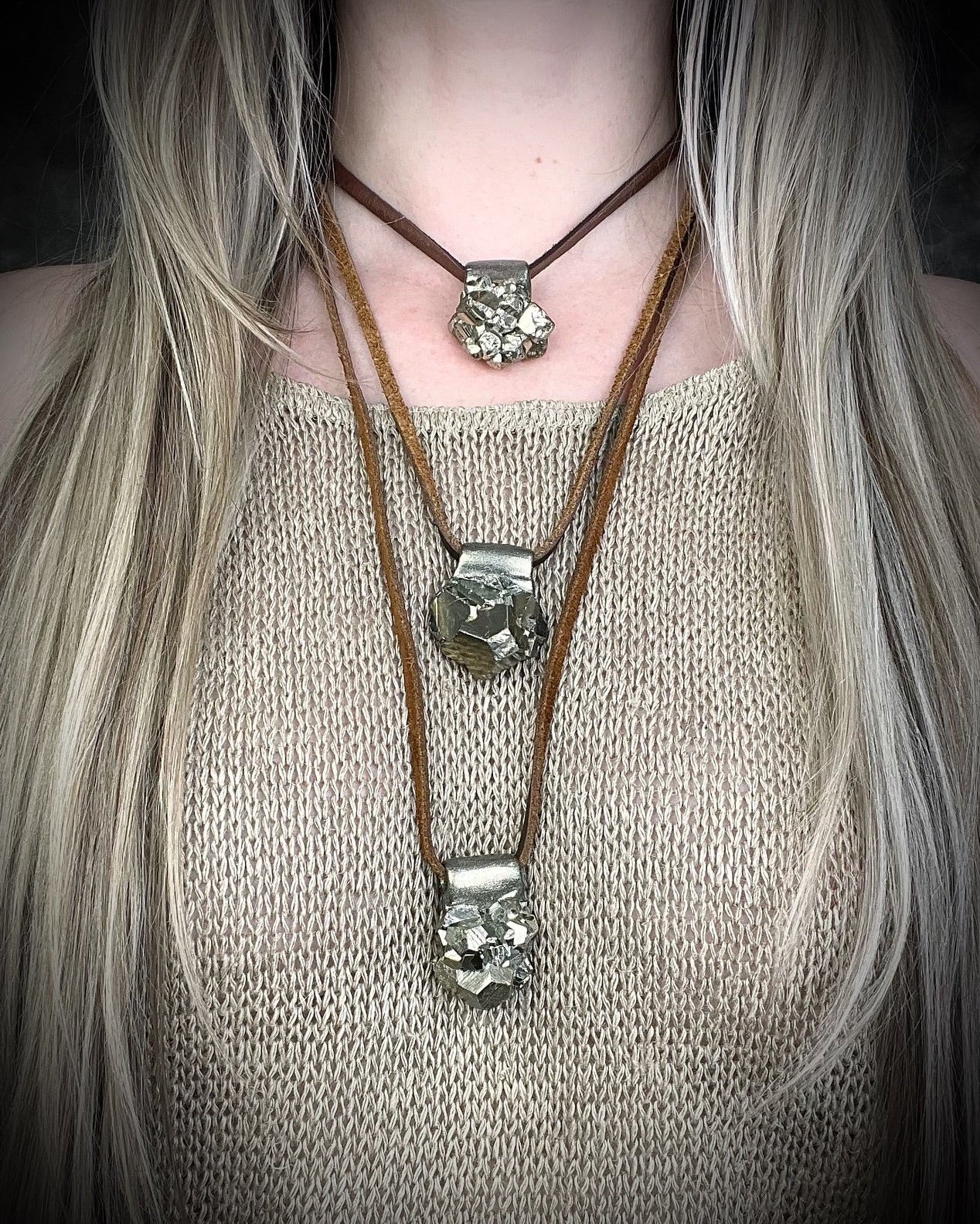 A person wearing 3 layering necklaces featuring pyrite crystals for grounding and abundance. manifestation jewelry for the boho spiritual soul. 
