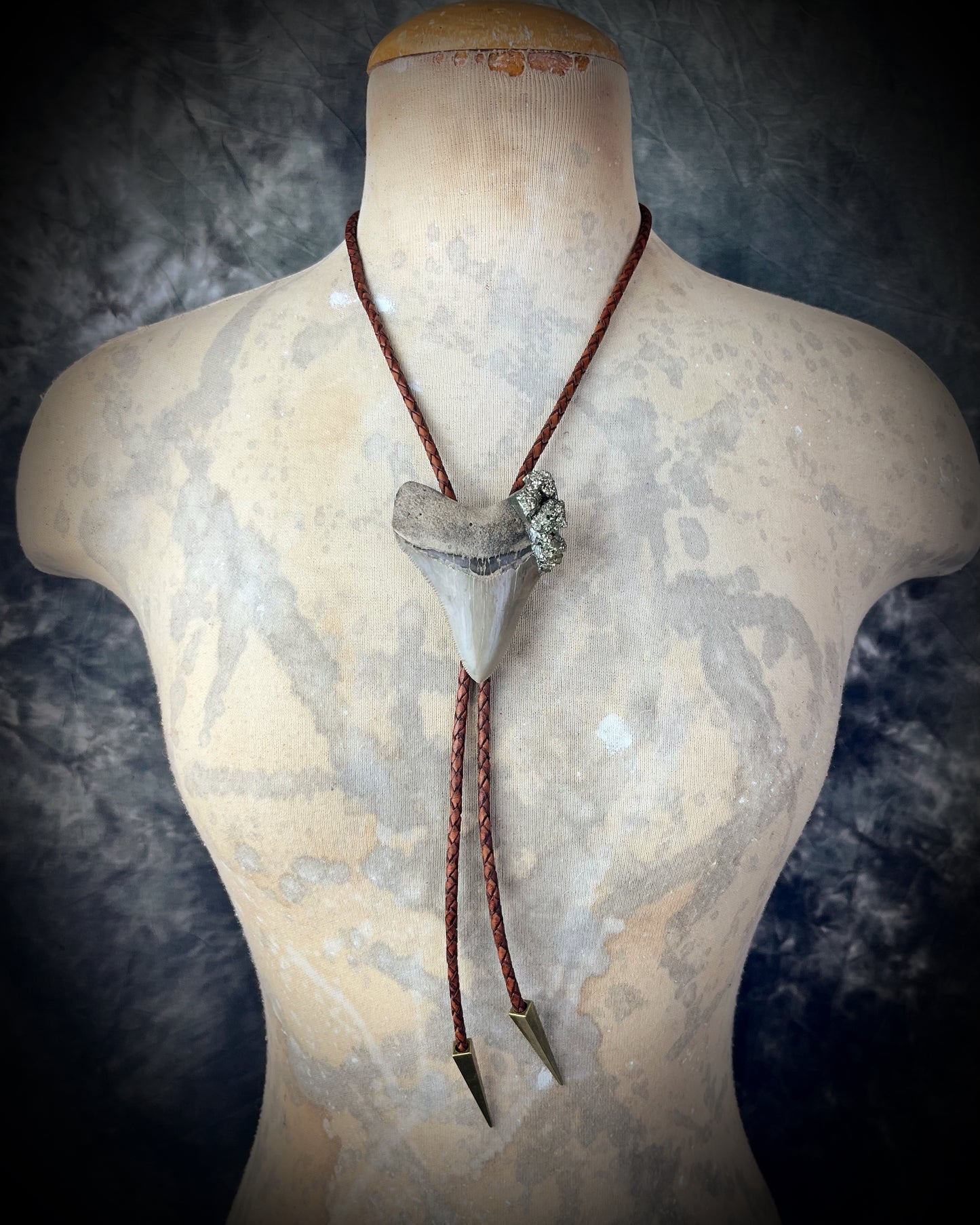 A prehistoric Megalodon tooth bolo tie adorned with shimmering Pyrite crystals on soft brown bolo leather. Maximalist Western style trend holiday gift for him!