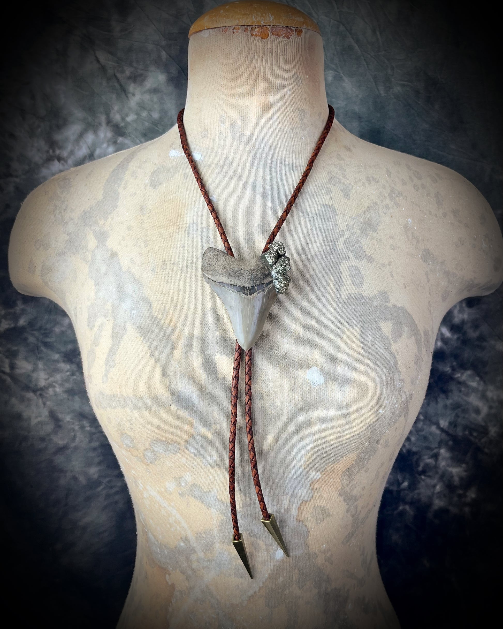 A prehistoric Megalodon tooth bolo tie adorned with shimmering Pyrite crystals on soft brown bolo leather. Maximalist Western style trend holiday gift for him!