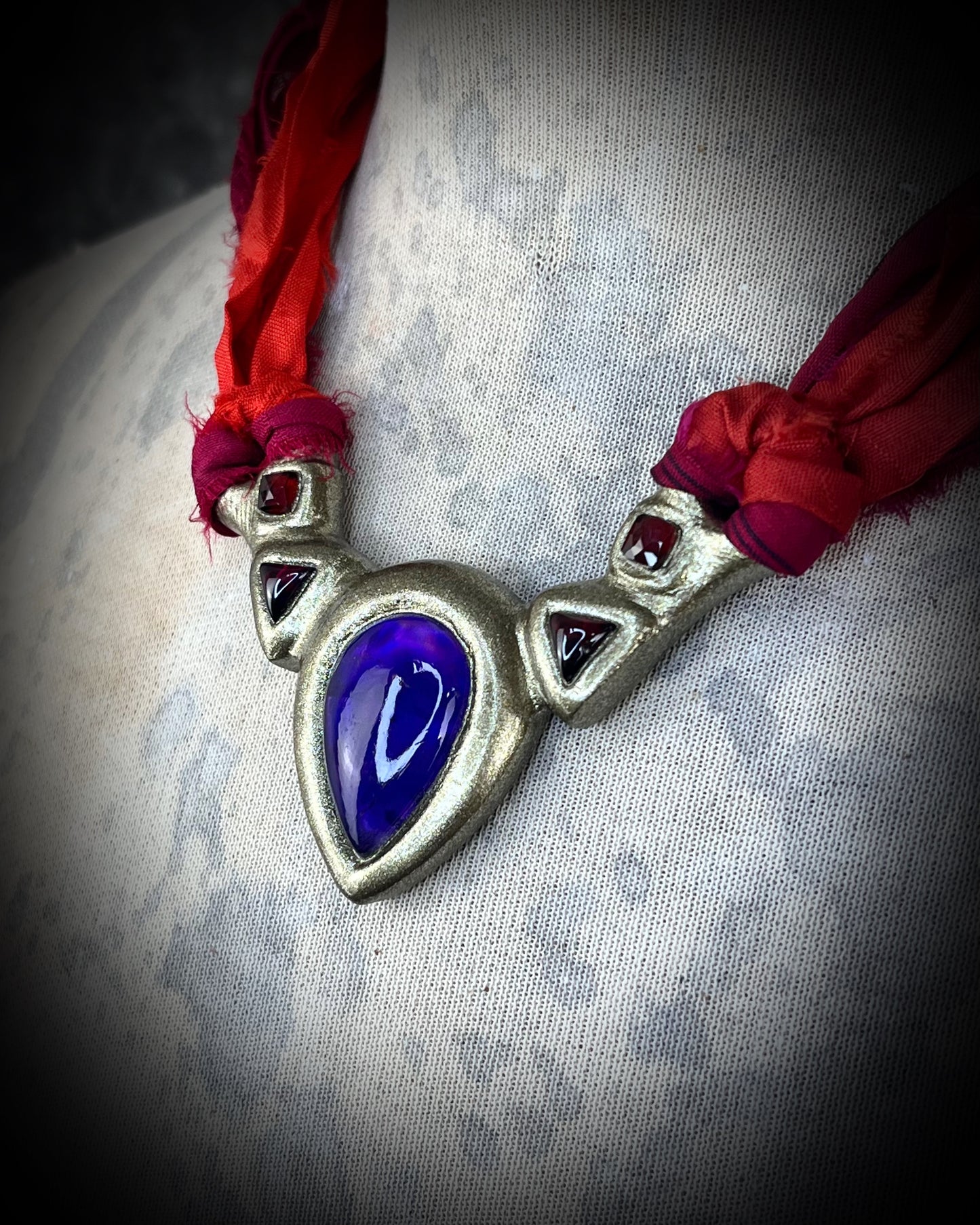 Amethyst and Garnet Birthstone Crystal Healing Collar Talisman – A regal gift for 2026 that enhances inner peace, psychic channels, and protection. Handcrafted in the USA and hung from red recycled silk for the sustainable Queen.