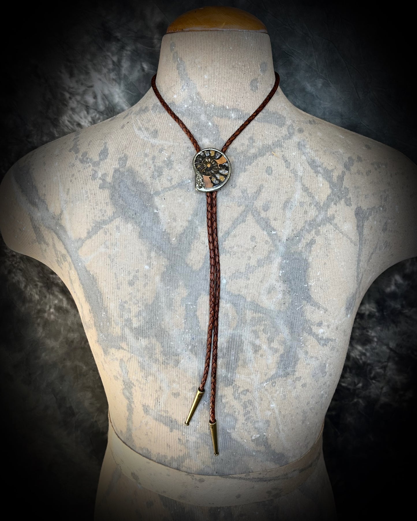 Ammonite and pyrite bolo tie styled with a male bust — unisex statement accessory
