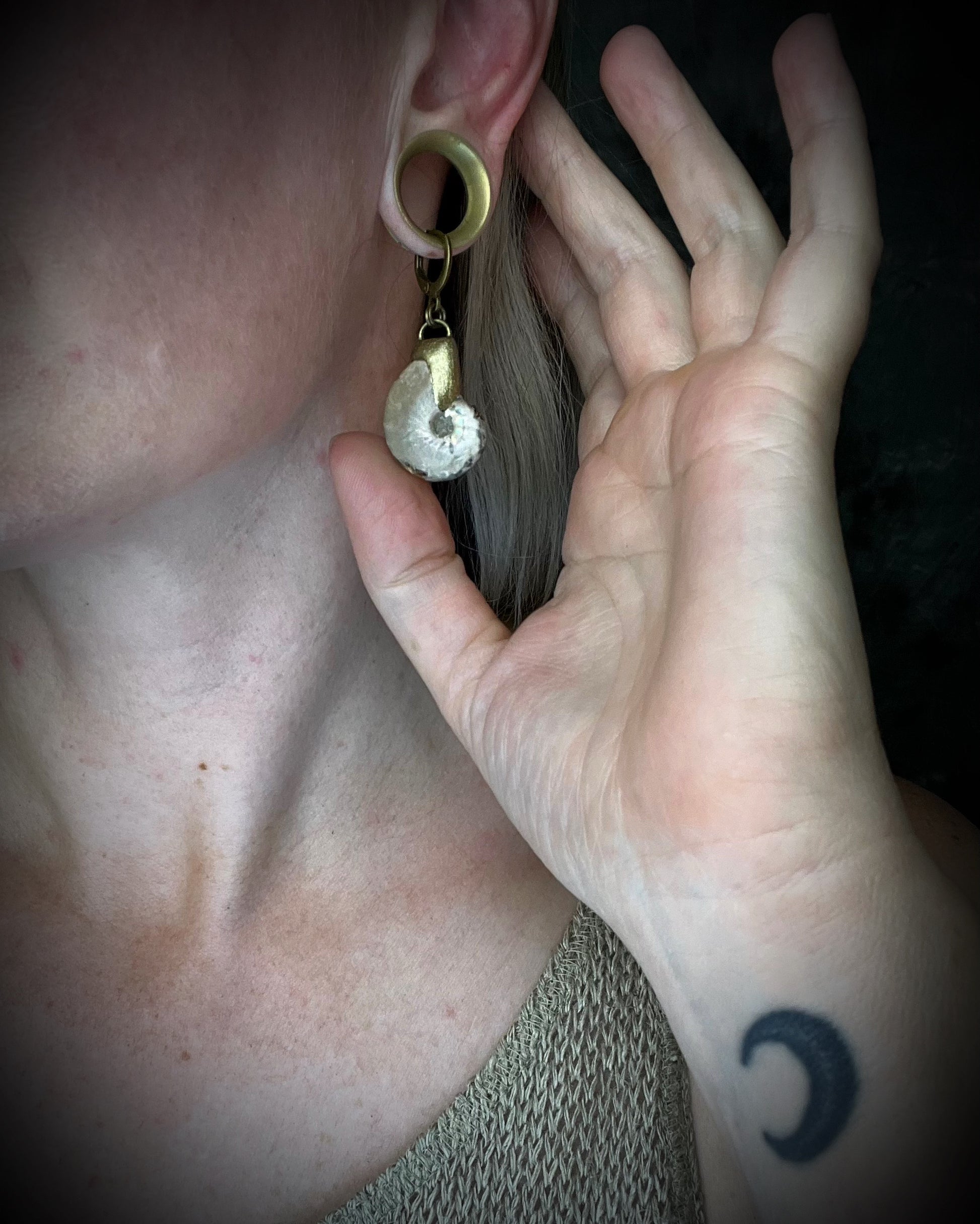 Ammonite fossil earrings featuring ancient spiral fossil forms on hypoallergenic huggie hooks, handmade by Become Spellbound.